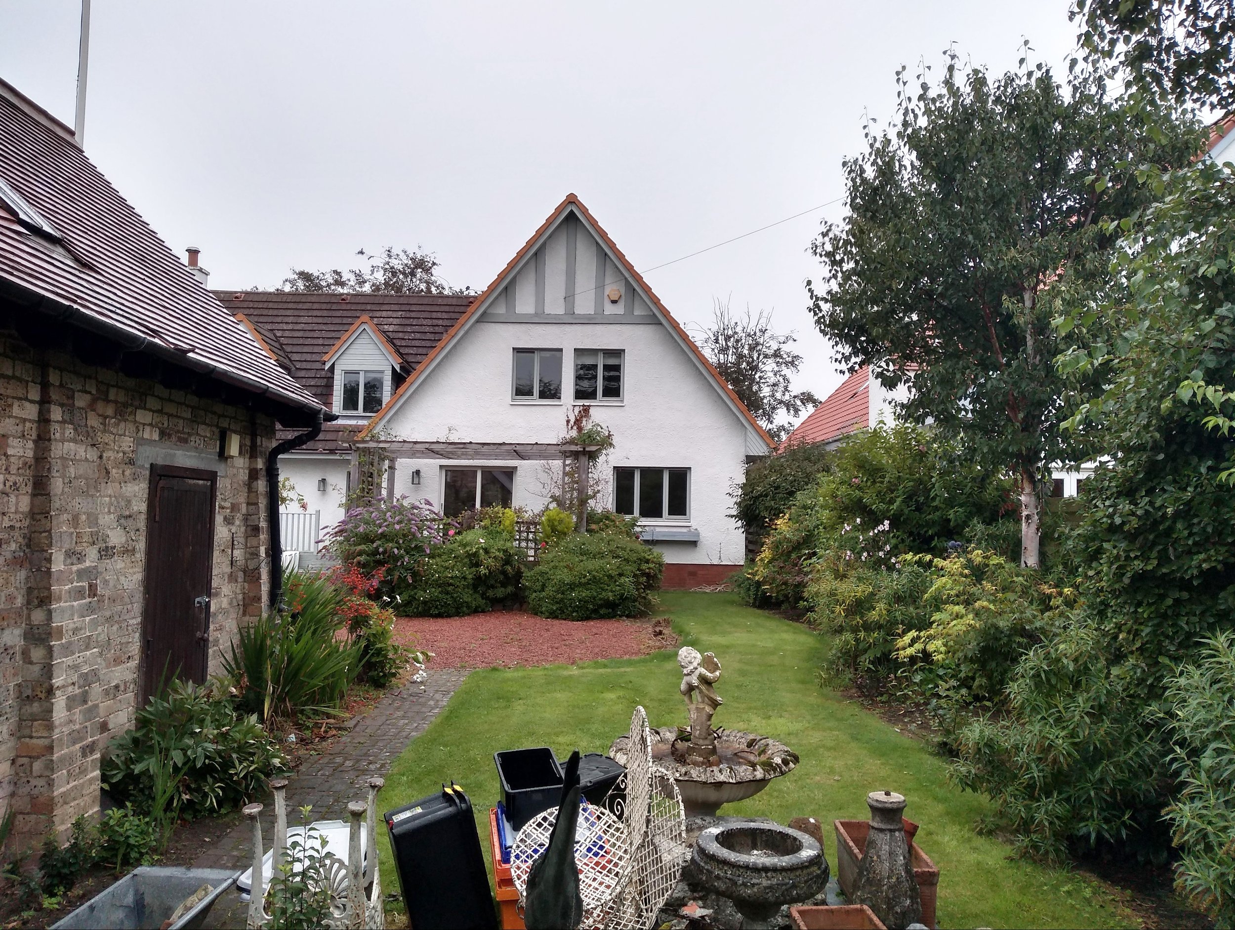 A lawn with a jumble of objects piled in the middle of the grass.