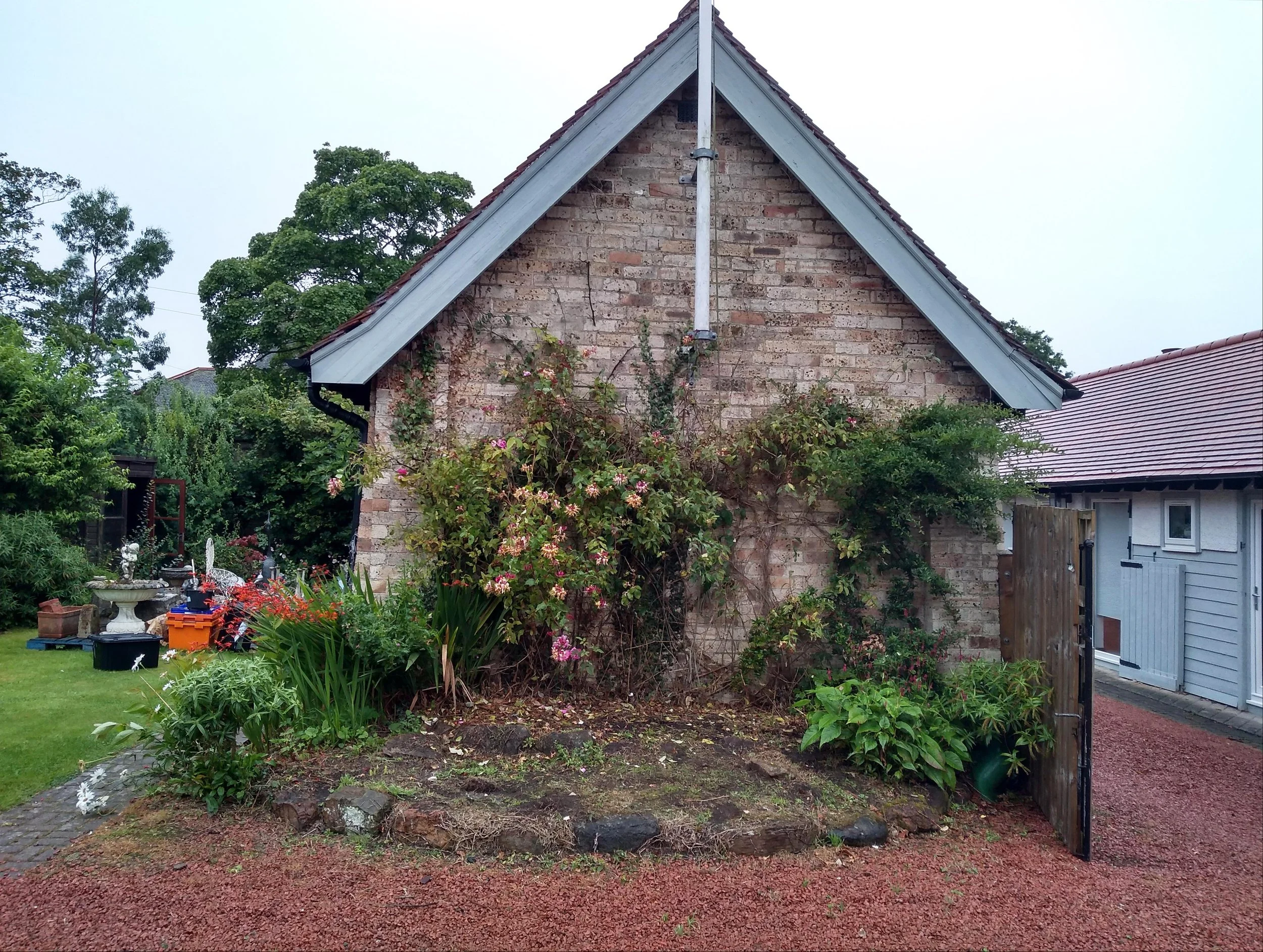 A tired looking planting bed with sparse planting.