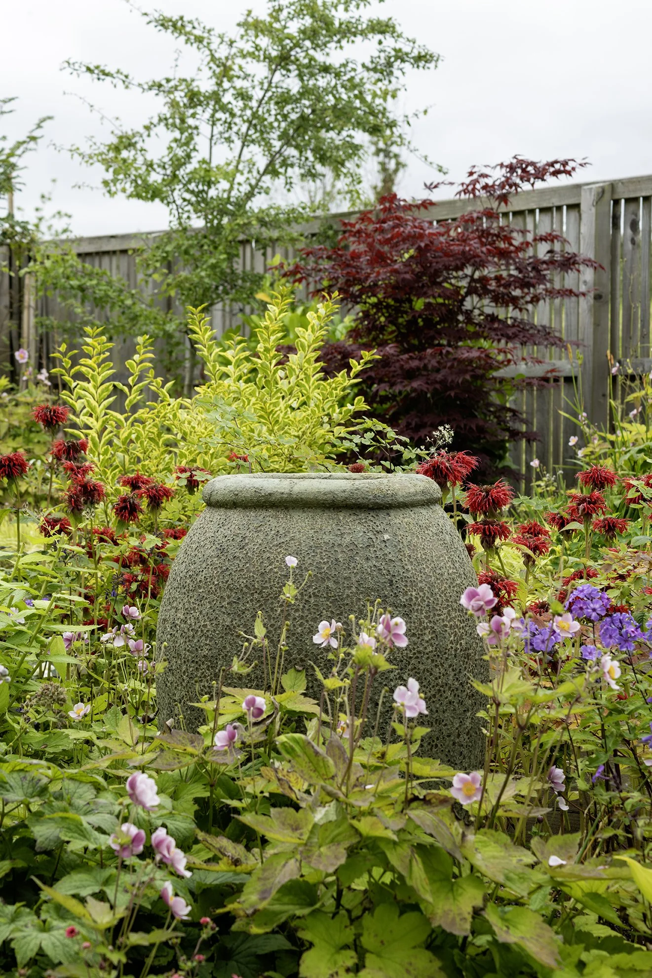 A close up of an ornamental urn in a beautiful garden