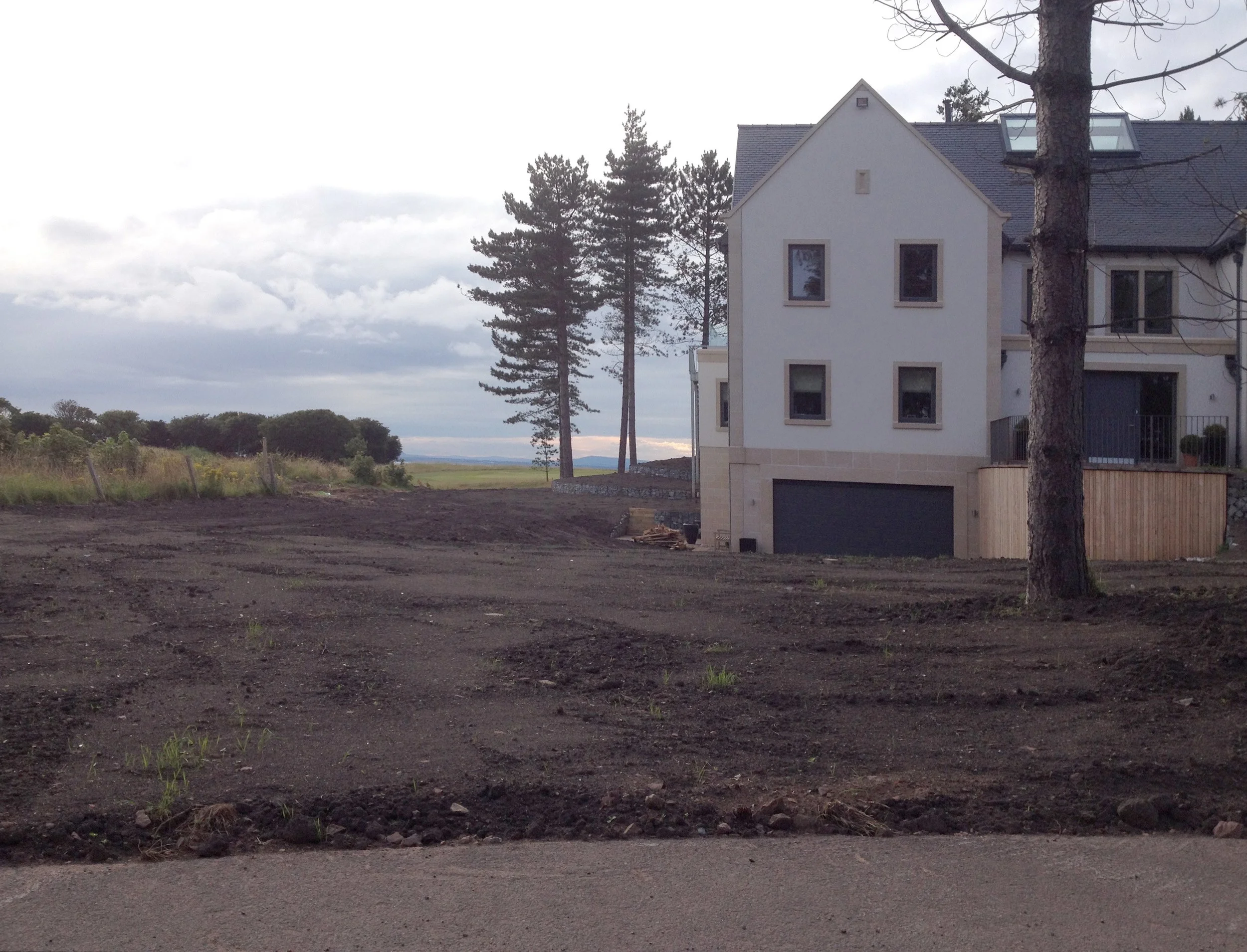 Bare earth surrounding a newly built house.