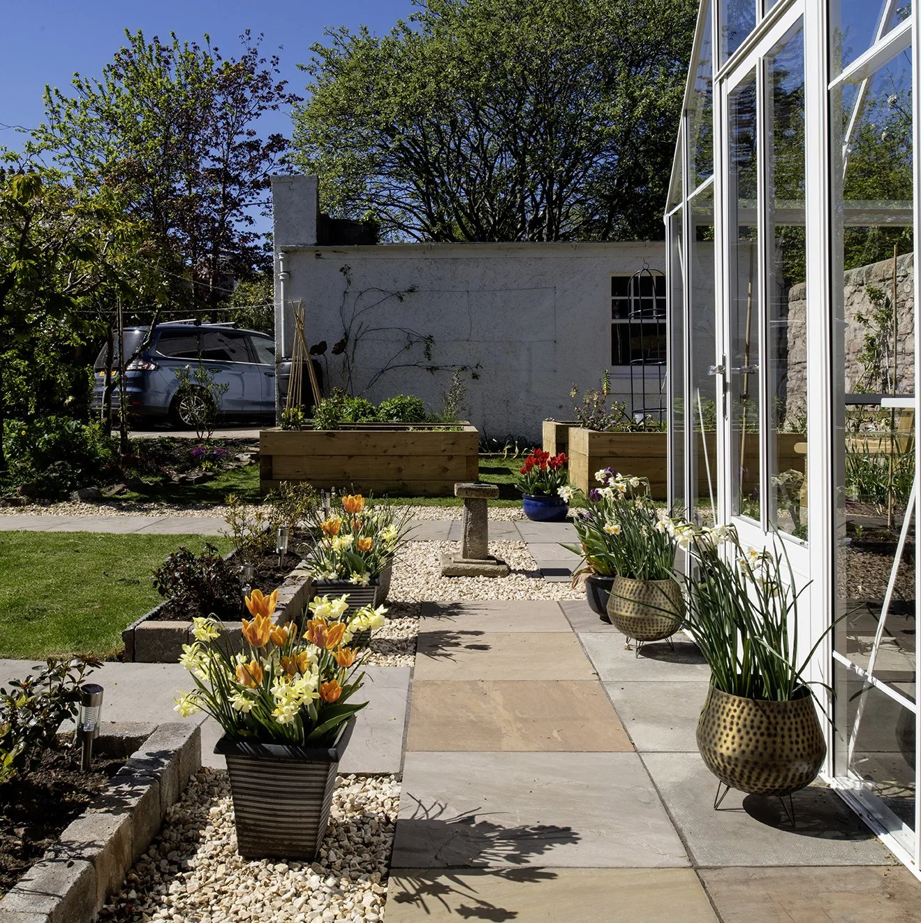 A sundial sits in a well planned kitchen garden.