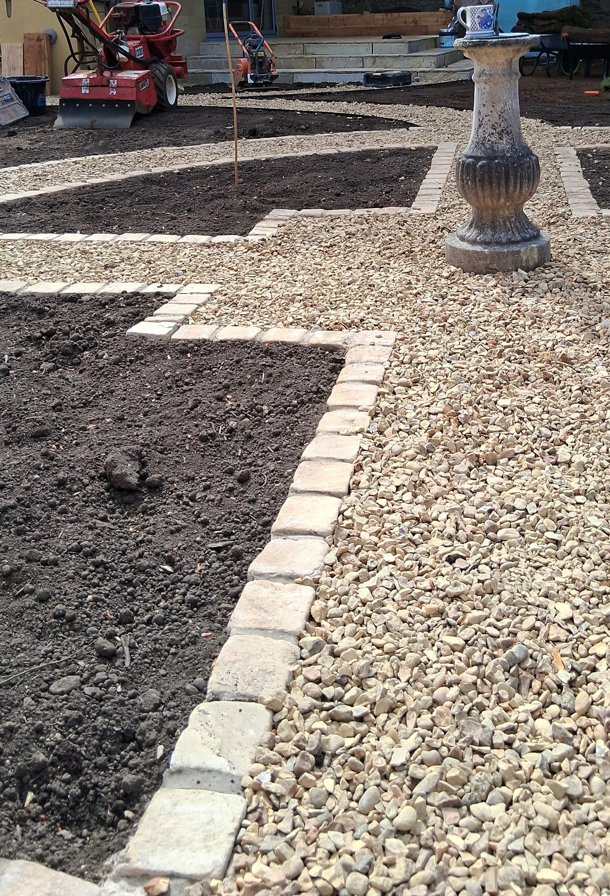 Close up of a sundial in the centre of a circular Potager garden.