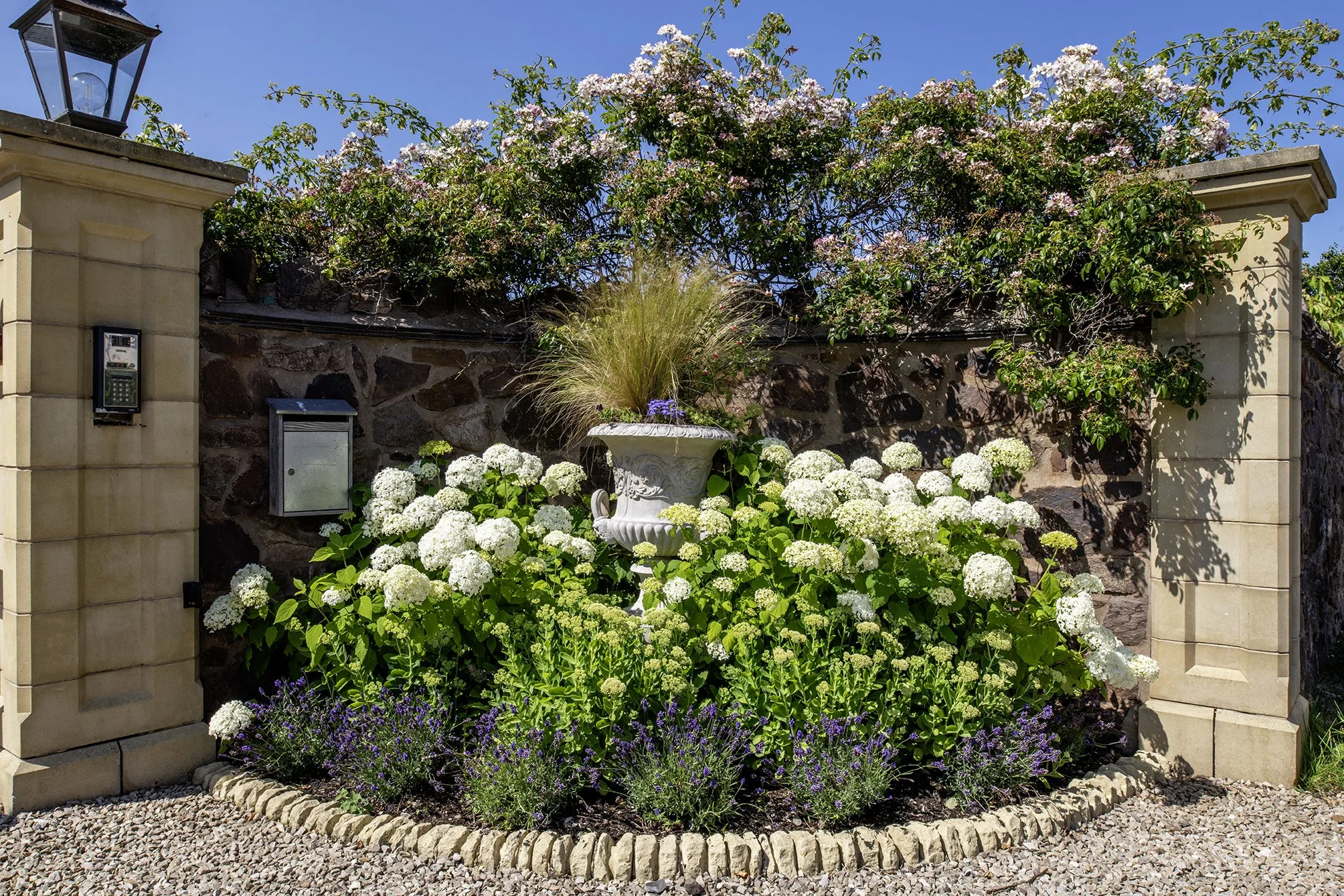Garden entrance bed with hydrangeas and ornamental urn
