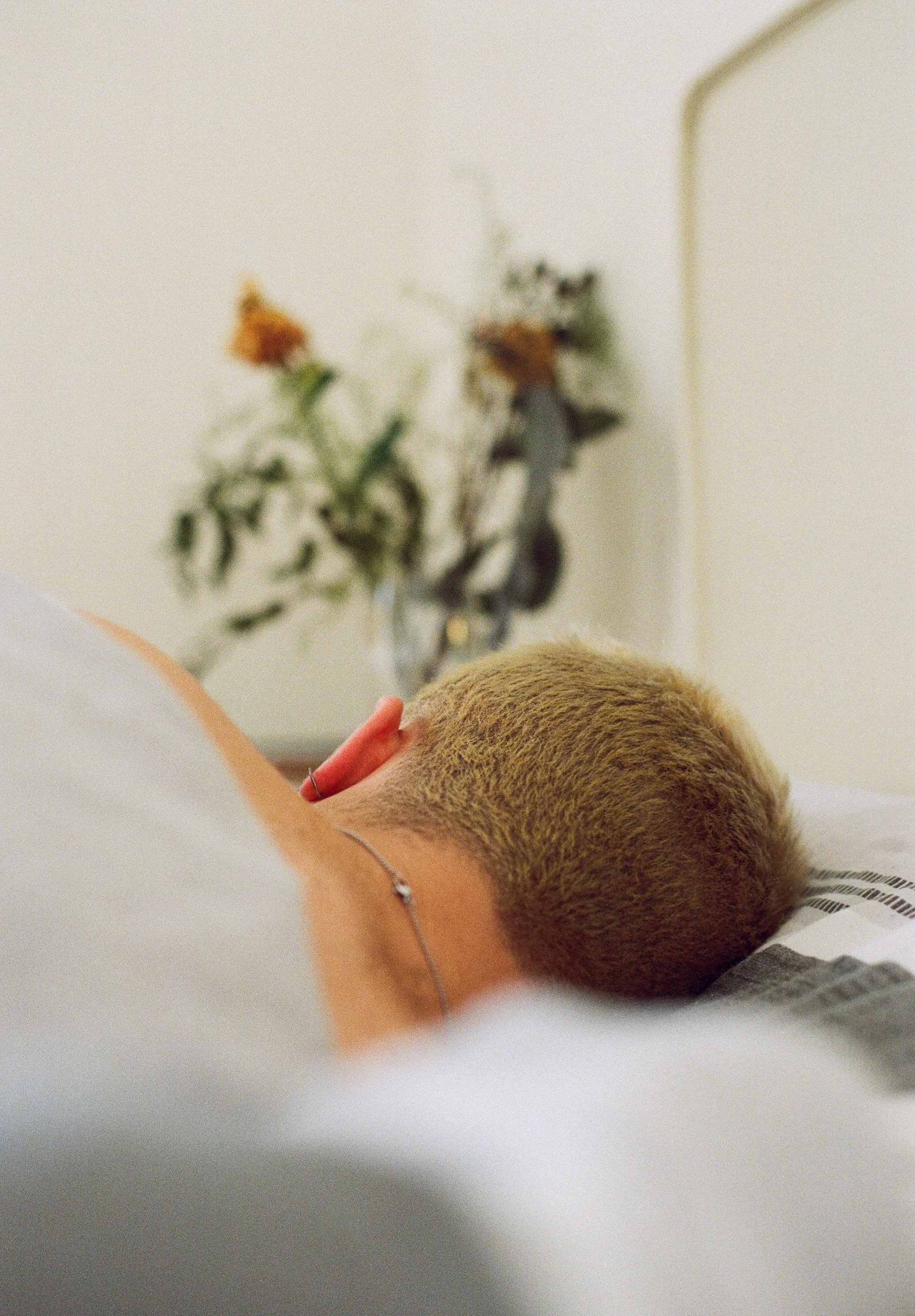 Portrait of boy sleeping in bed taken from the back.