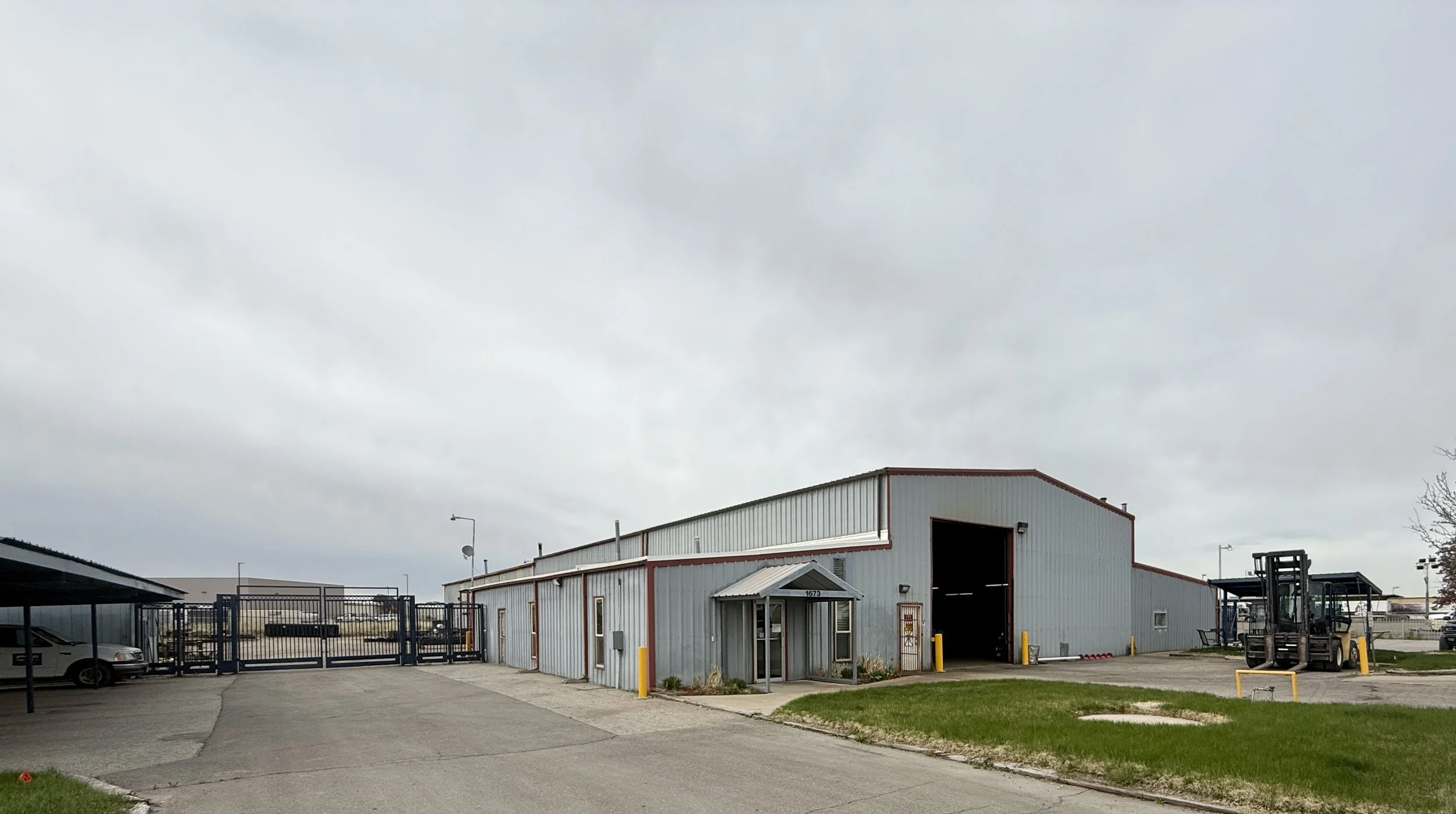 Industrial property — warehouse, loading entrance, and secured yard.