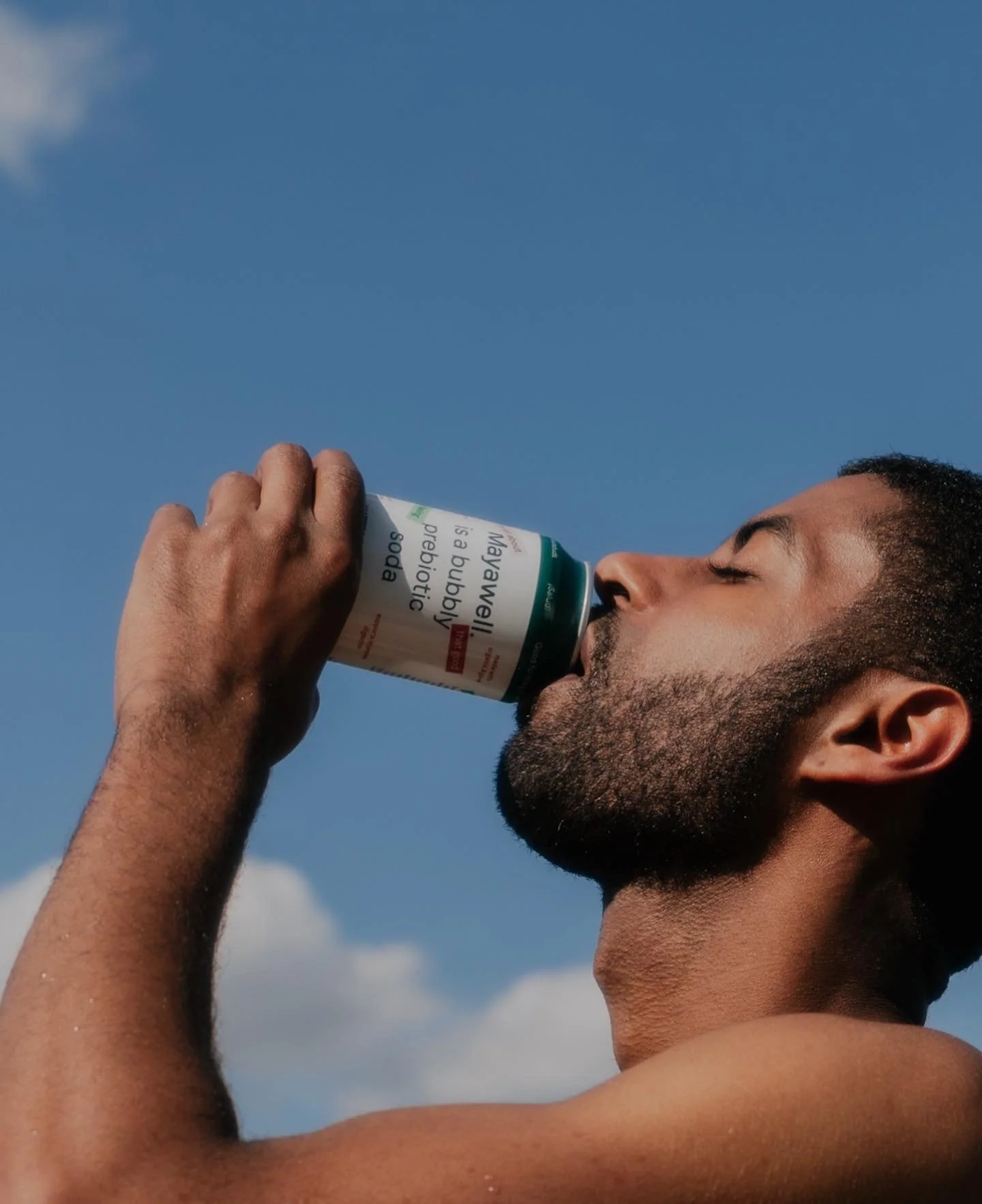Patrick Sims enjoying Mayawell probiotic soda in a poolside lifestyle campaign.