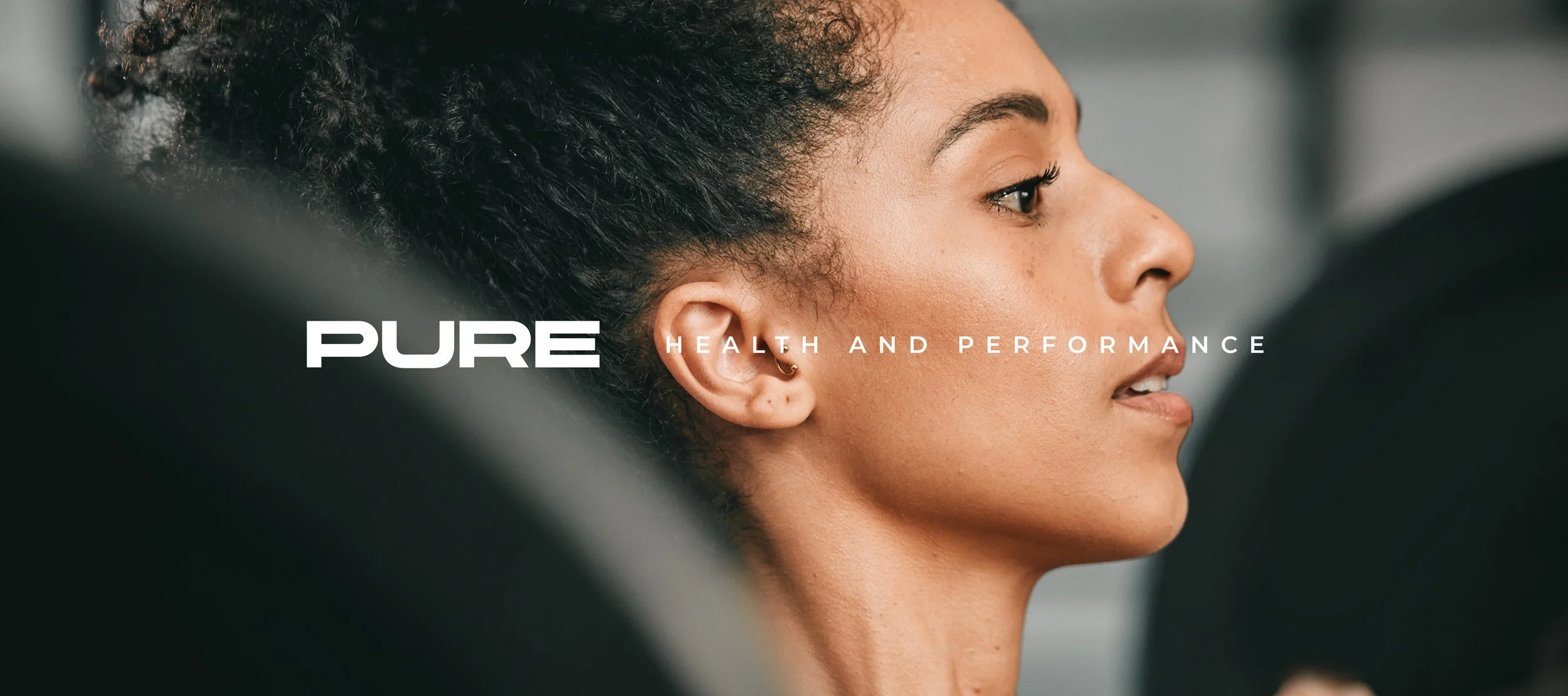 Brand-led portrait of a focused female athlete paired with the Pure Strength wordmark and “Health and Performance” message, expressing clarity, control, and a high-performance training mindset.