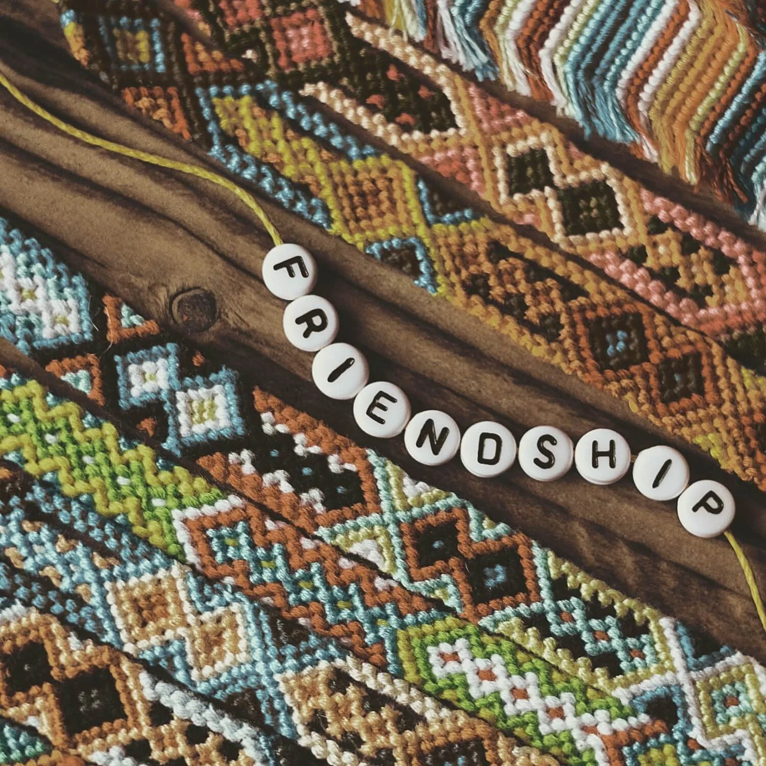 “Friendship” spelled on colorful woven fabric, symbolizing connection, support, and meaningful relationships