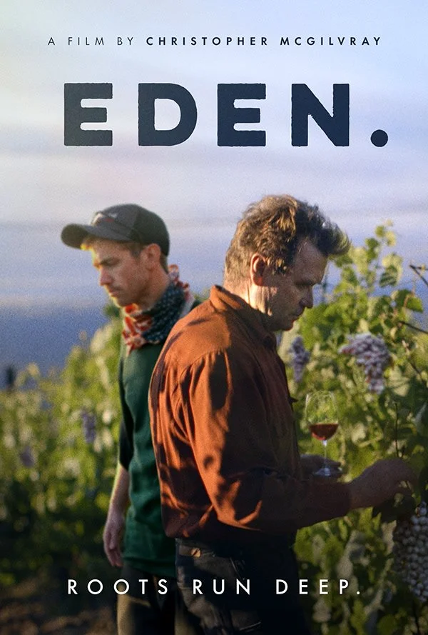 Film poster for 'Eden' by Christopher McGilvray, depicting two men in a vineyard with one holding a glass of wine.