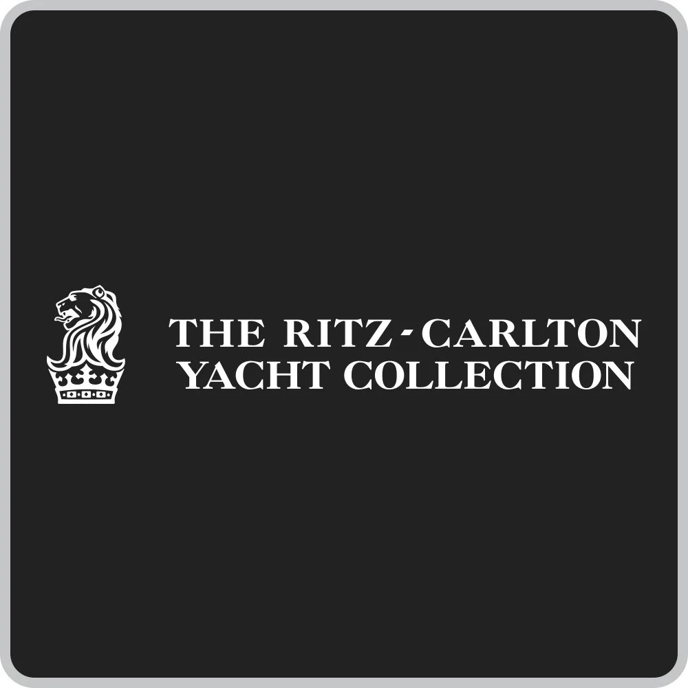 Black background with white text reading "The Ritz-Carlton Yacht Collection" and a logo of a lion's head with a crown.