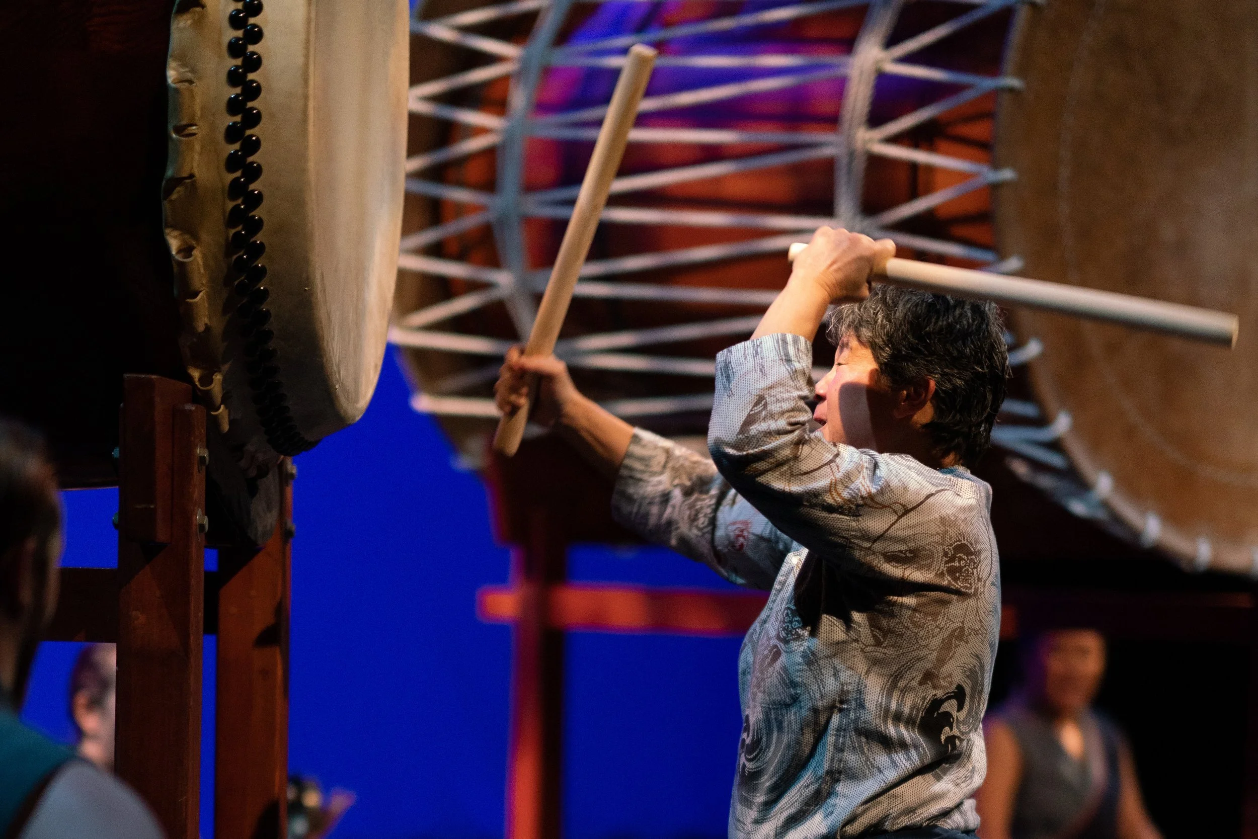 Taiko master Tiffany Tamaribuchi strikes a large drum.