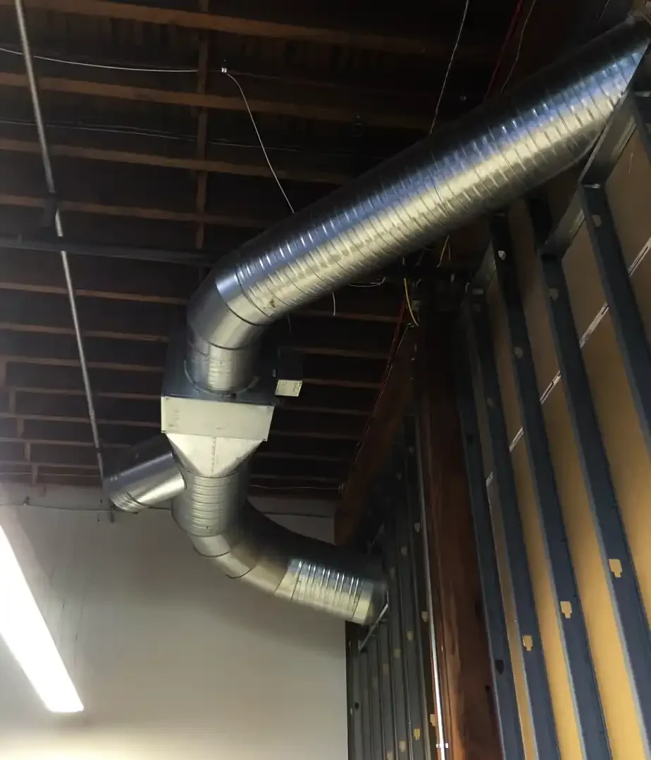 Close-up of a press brake bending sheet metal for custom HVAC ductwork fabrication, highlighting precision craftsmanship used in commercial and residential systems.