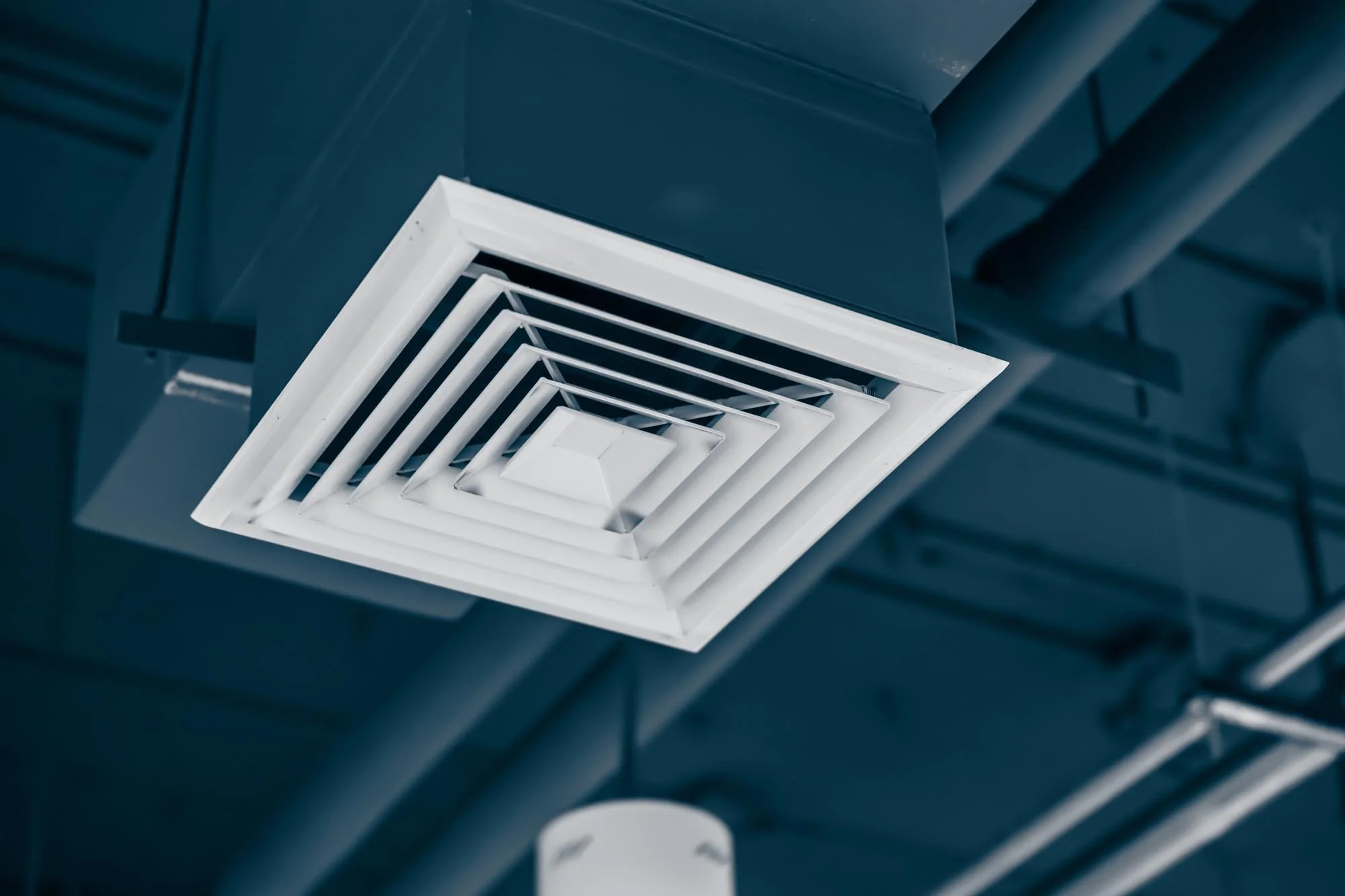 Close-up of a commercial ceiling vent diffuser in a ducted HVAC system