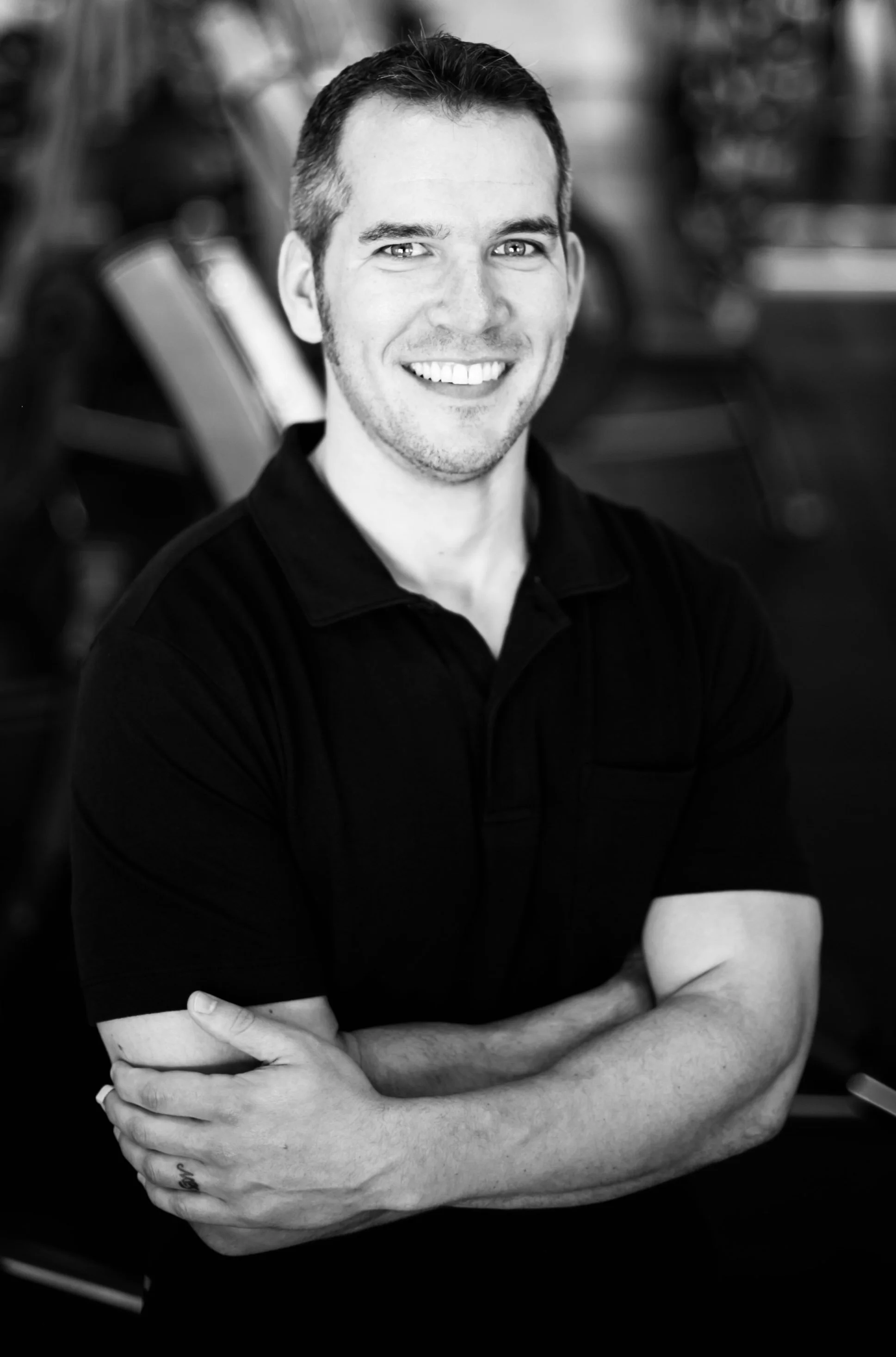 Photograph of J.J. Creegan smiling with crossed arms, conveying confident, approachable leadership.
