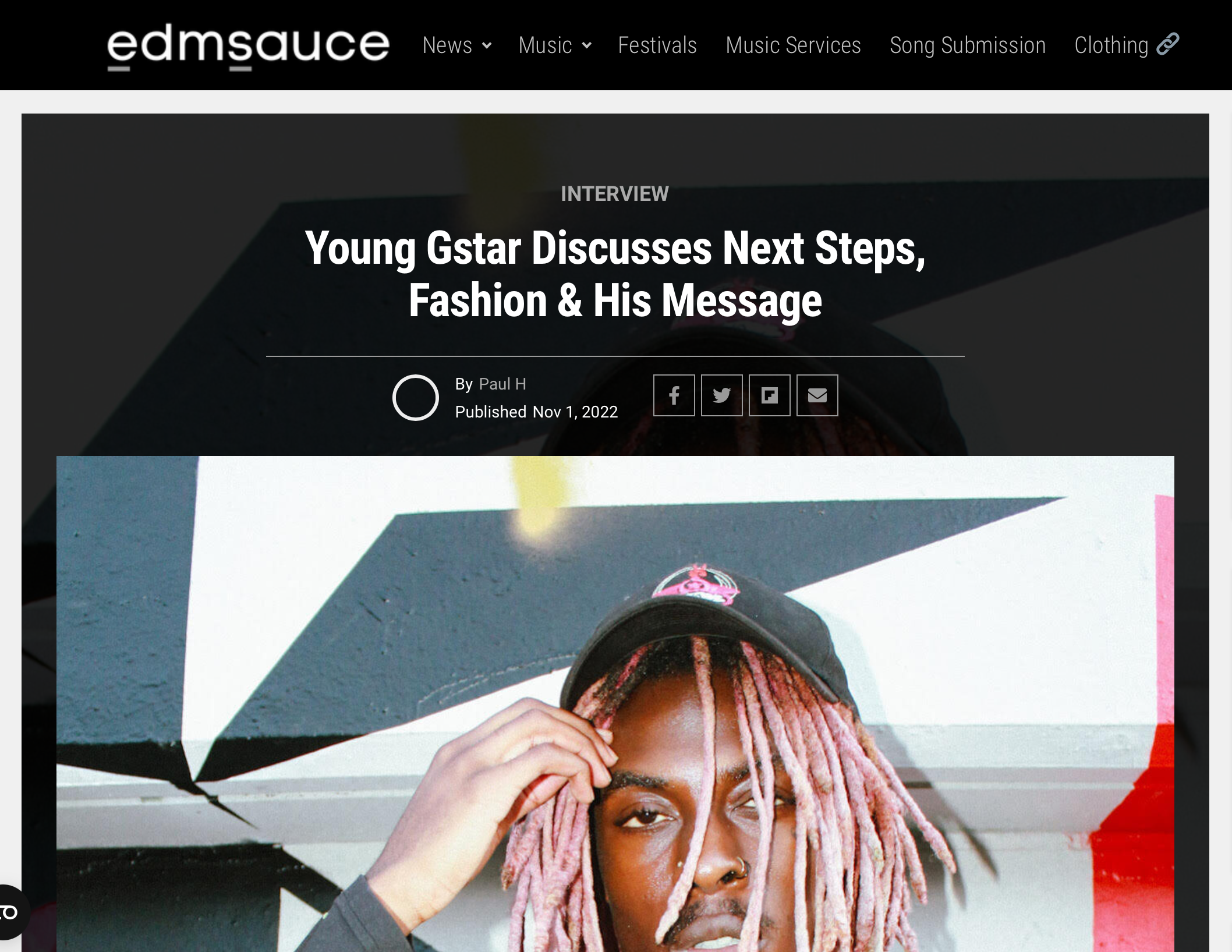 Screenshot of an article from EDM Sauce titled "Young Gstar Discusses Next Steps, Fashion & His Message," published on November 1, 2022 by Paul H. The website header includes links to News, Music, Festivals, Music Services, Song Submission, and Clothing. The image below the title shows a person with pink hair, wearing a hat, posing in front of a geometric mural.