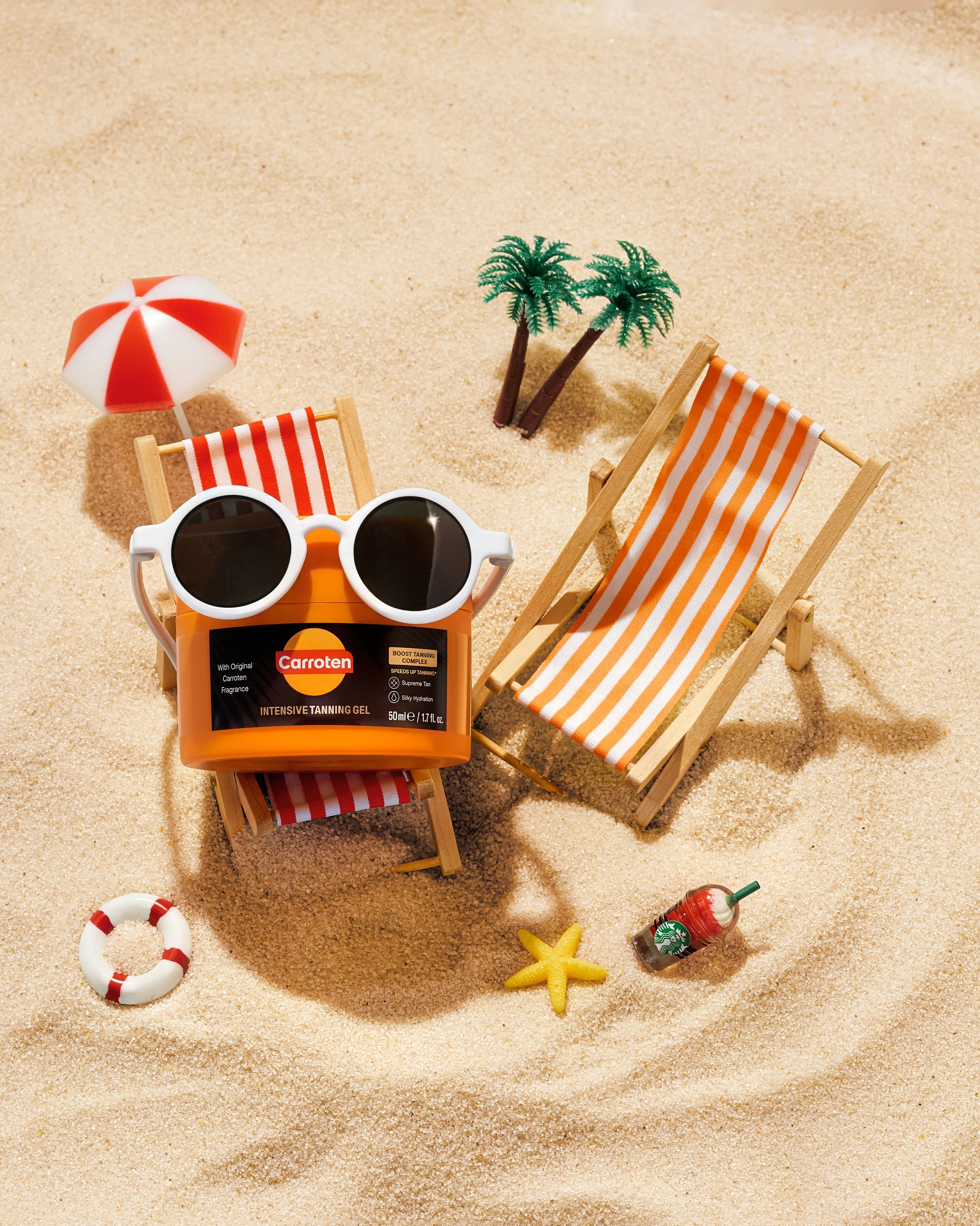 A playful beach scene featuring a vintage camera, sunglasses, and lounge chairs on sand, evoking summer fun and nostalgia for SAYN Beauty's sun tan line - Carroten. 