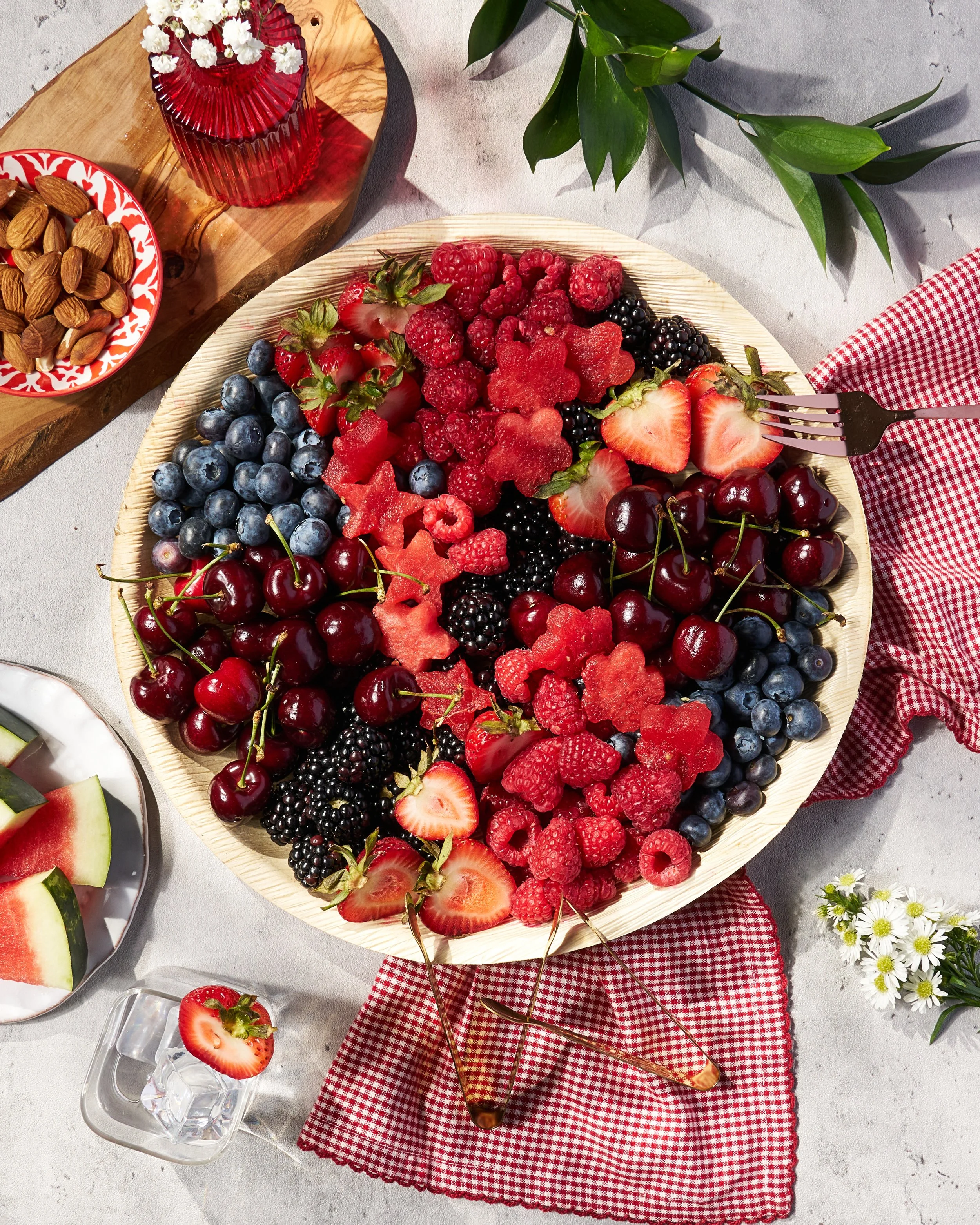A large bowl of a variety of berries is shot from on top with bright lighting