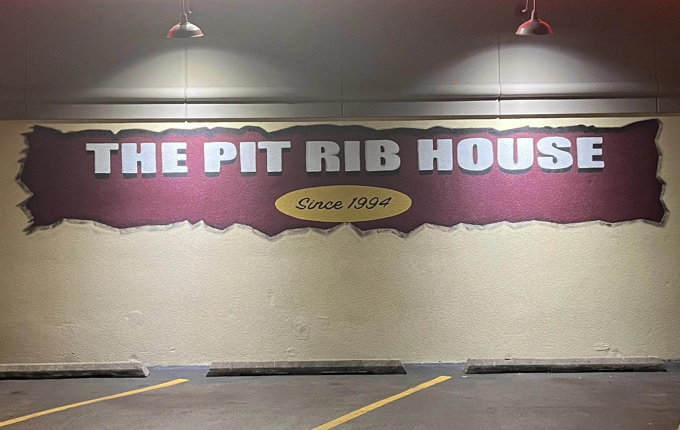 An image of The Pit Rib House sign mural.