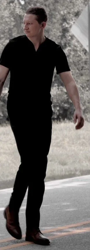 Person walking on a road in a black outfit