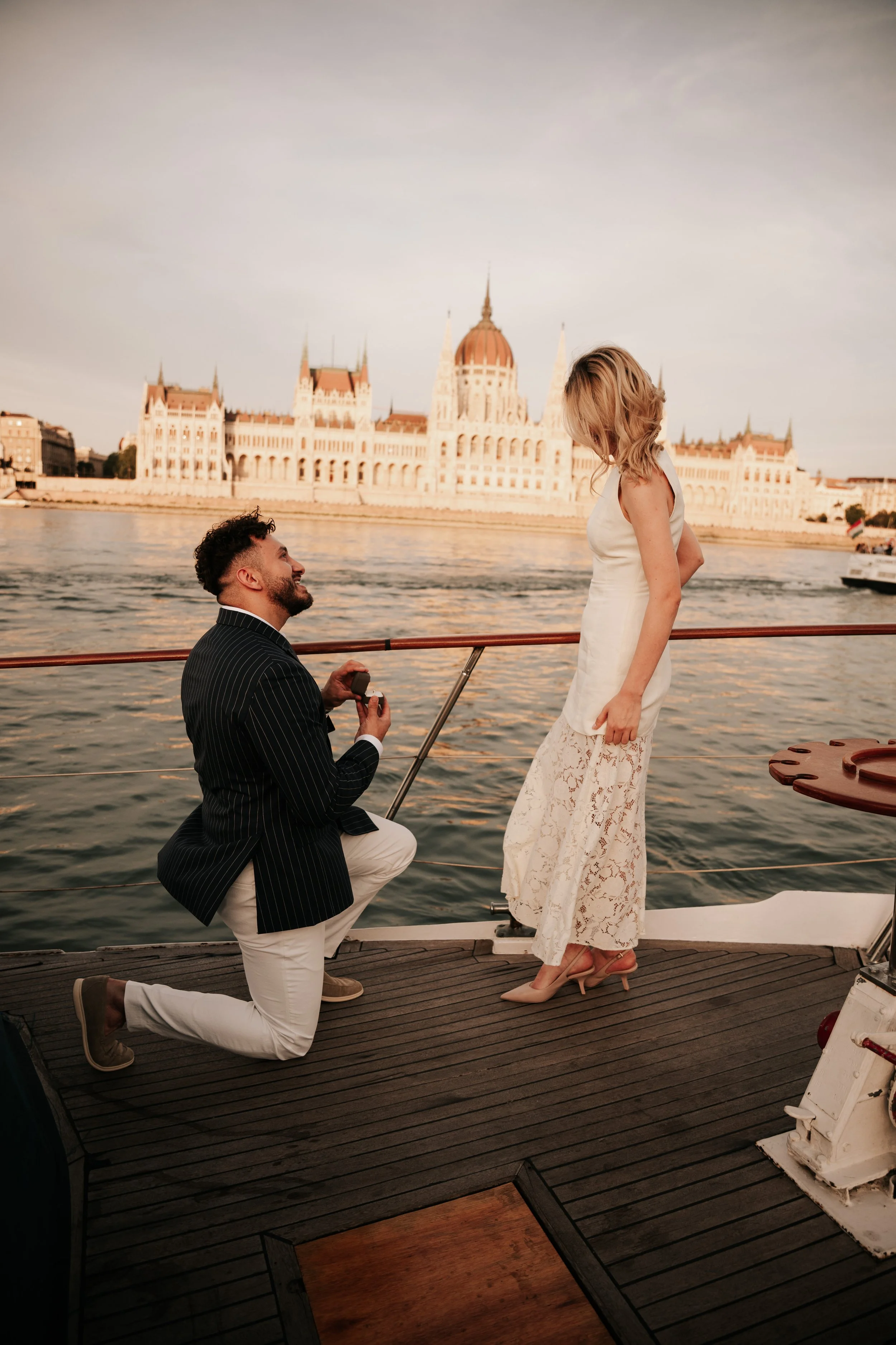 Celebrating engagement with champagne on Danube boat, Budapest Chain Bridge in background