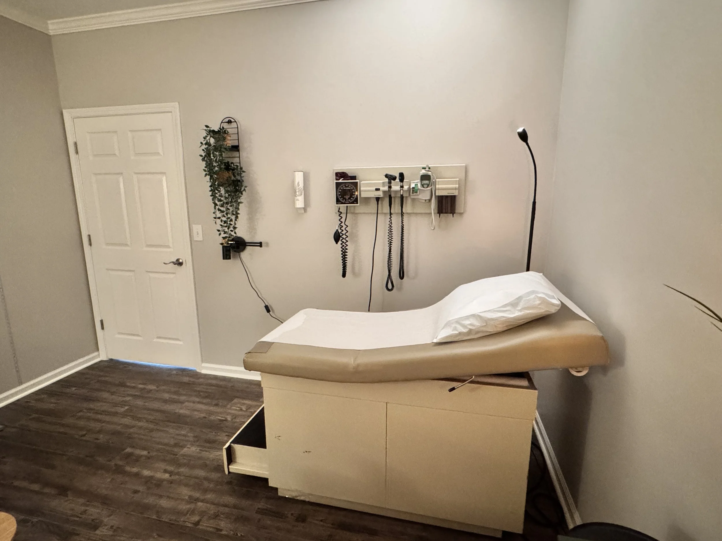 Medical examination room with exam table, medical instruments on the wall, and lamination on the floor.