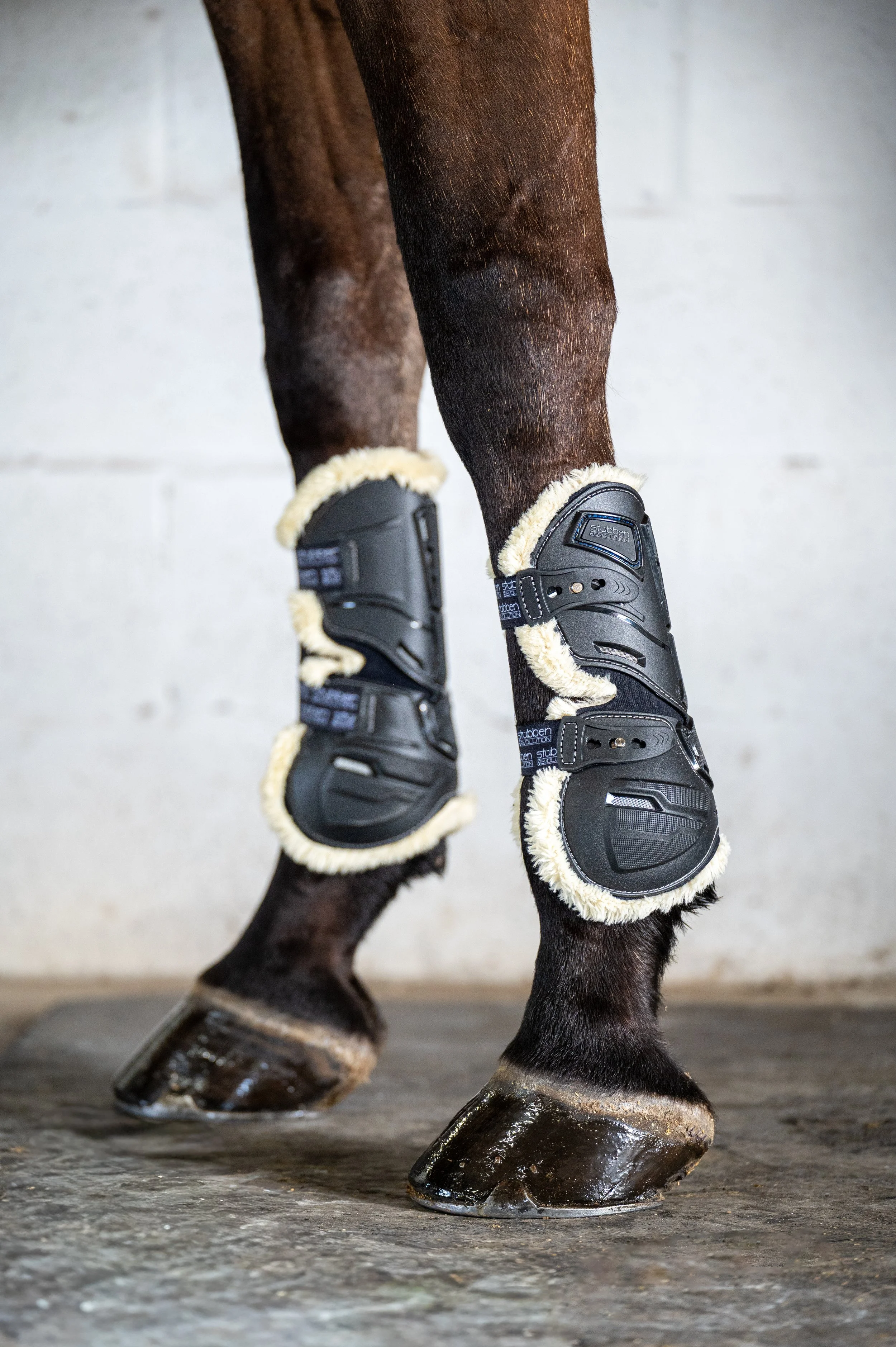 Close-up of a horse's legs wearing protective boots with shearling lining.