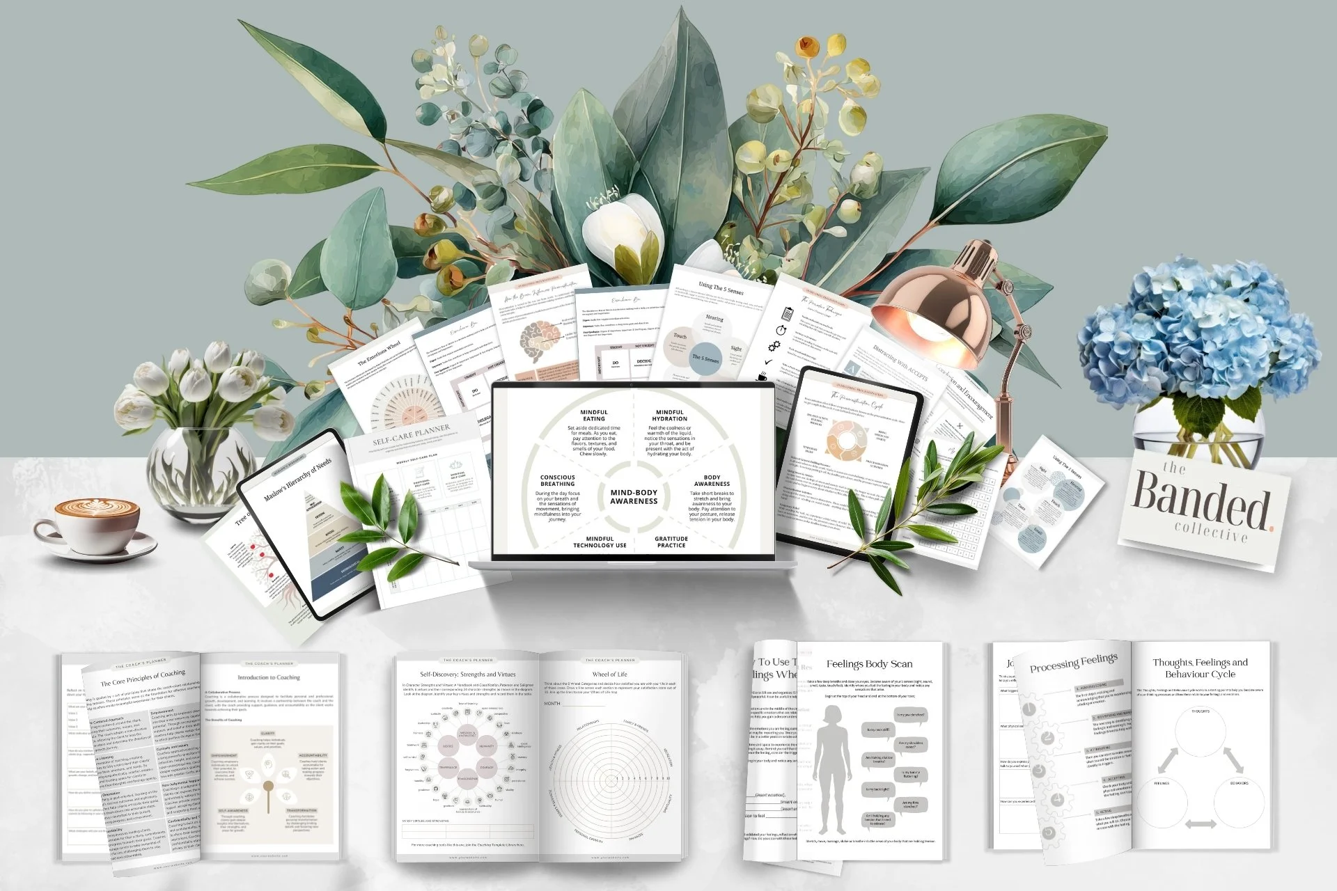 An organized collection of printed and digital materials related to mindfulness, coaching, and self-awareness, arranged on a table with floral decor and a desk lamp.