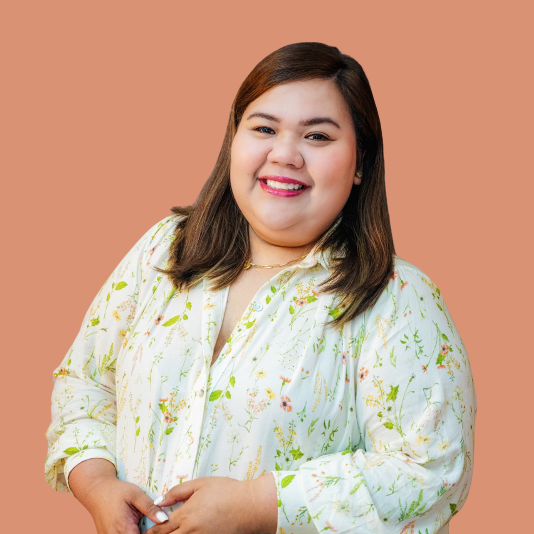 Smiling person wearing a floral blouse against a peach background. startup operations lead.