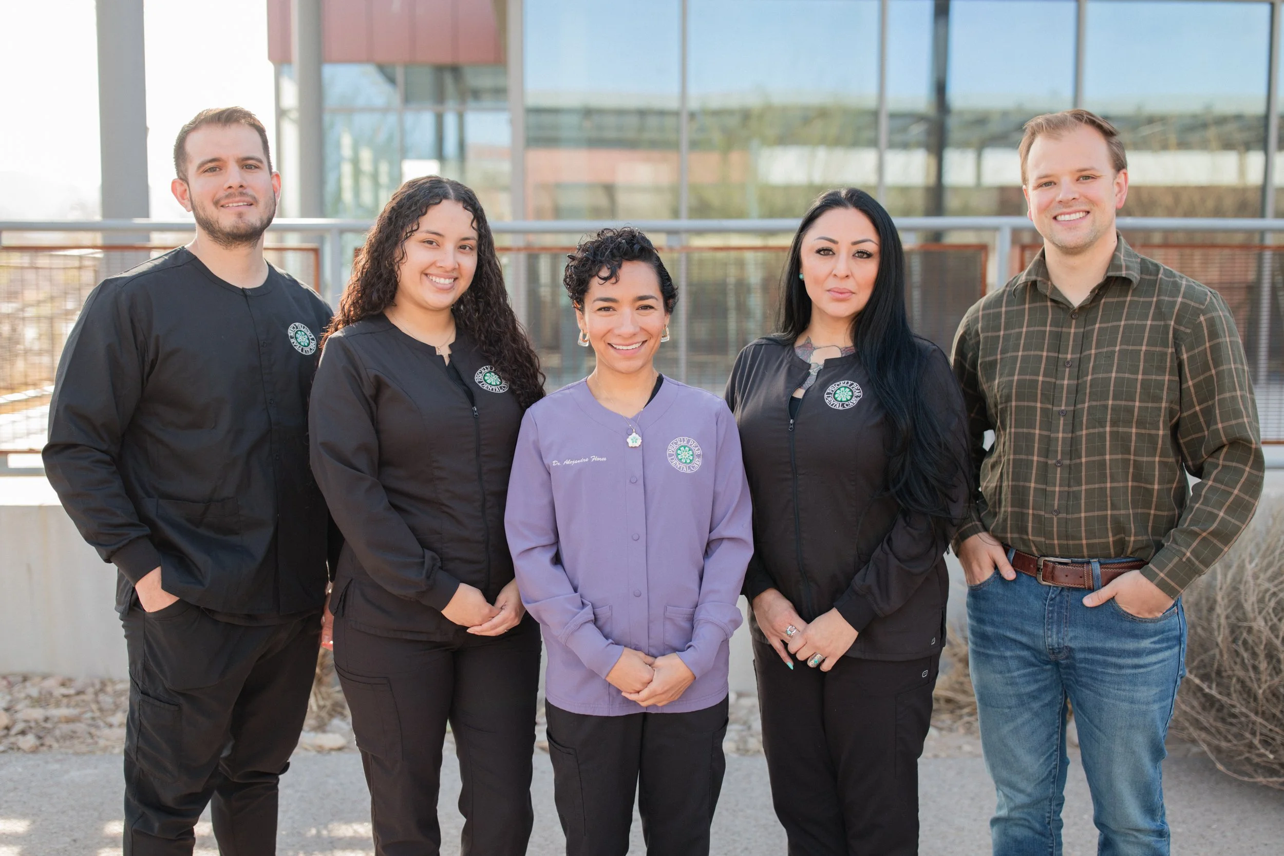 A photo of Dr. Flores and the Prickly Pear Dental Care staff taken in the outdoor space near the office.