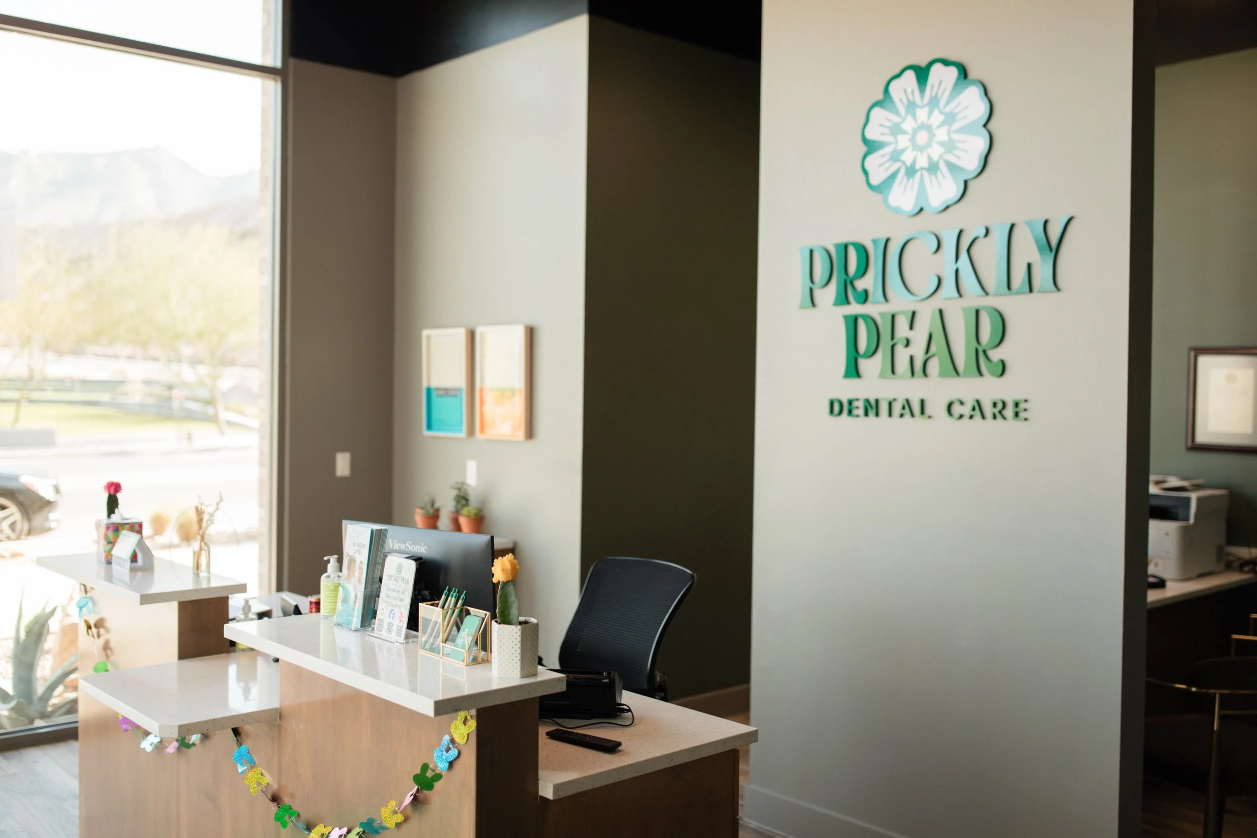 An image of the front-office area at Prickly Pear Dental Care, with El Paso's Franklin Mountains faintly visible outside.