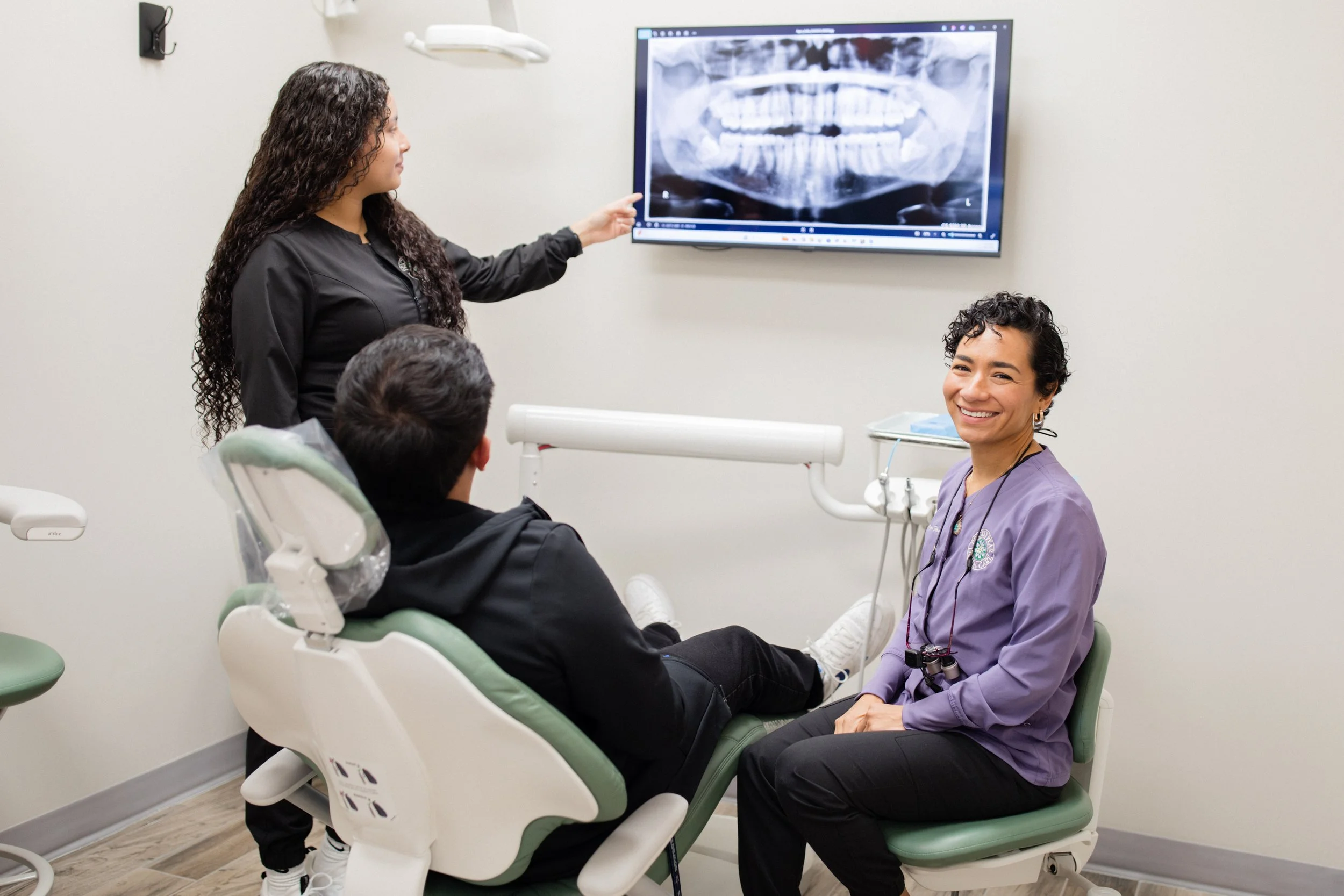 A photograph of Dr. Flores, a dental assistant, and a patient in one of the operatories here at Prickly Pear Dental Care.