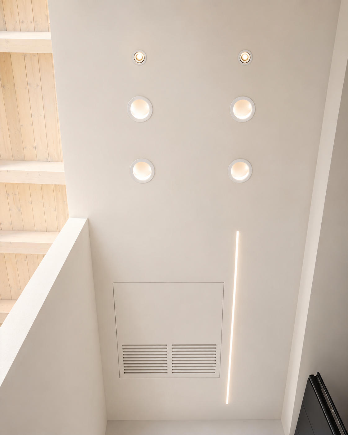 Botola filo muro a soffitto con faretti LED incassati e linea luminosa integrata.