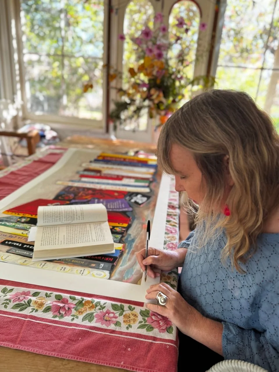 Sara Phemister signing a print in her home.