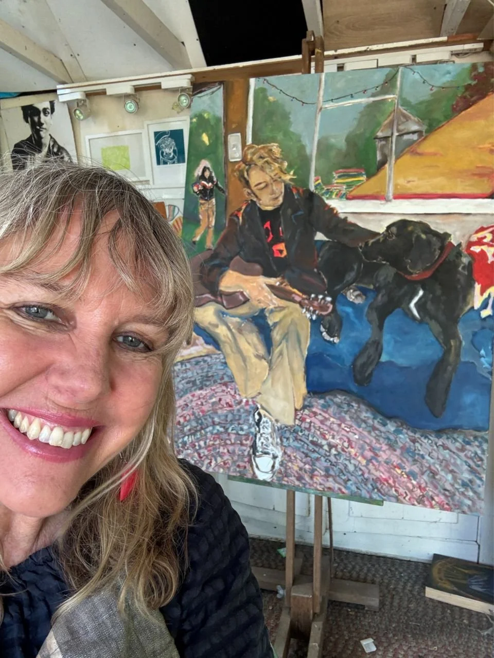 Sara Phemister smiling in front of one of her paintings.