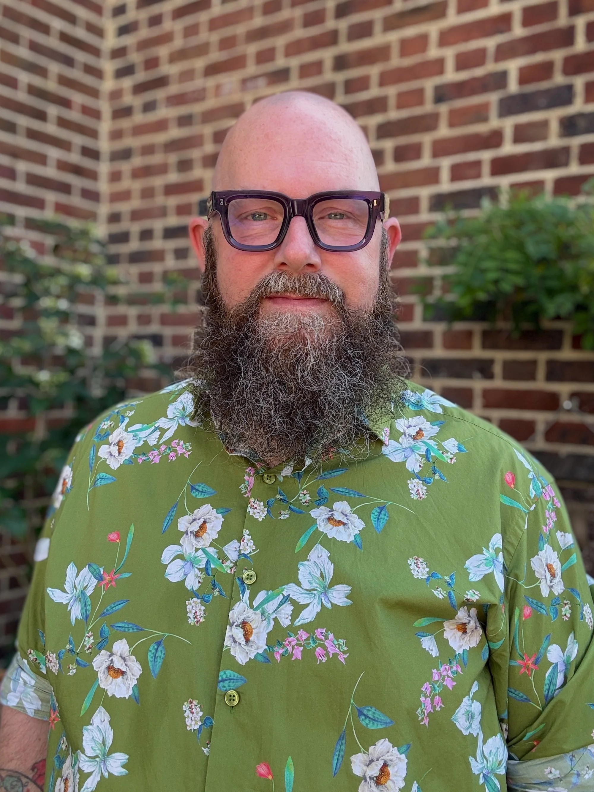 Dan Lee, therapist in Bethnal Green, East London, wearing a green floral shirt.