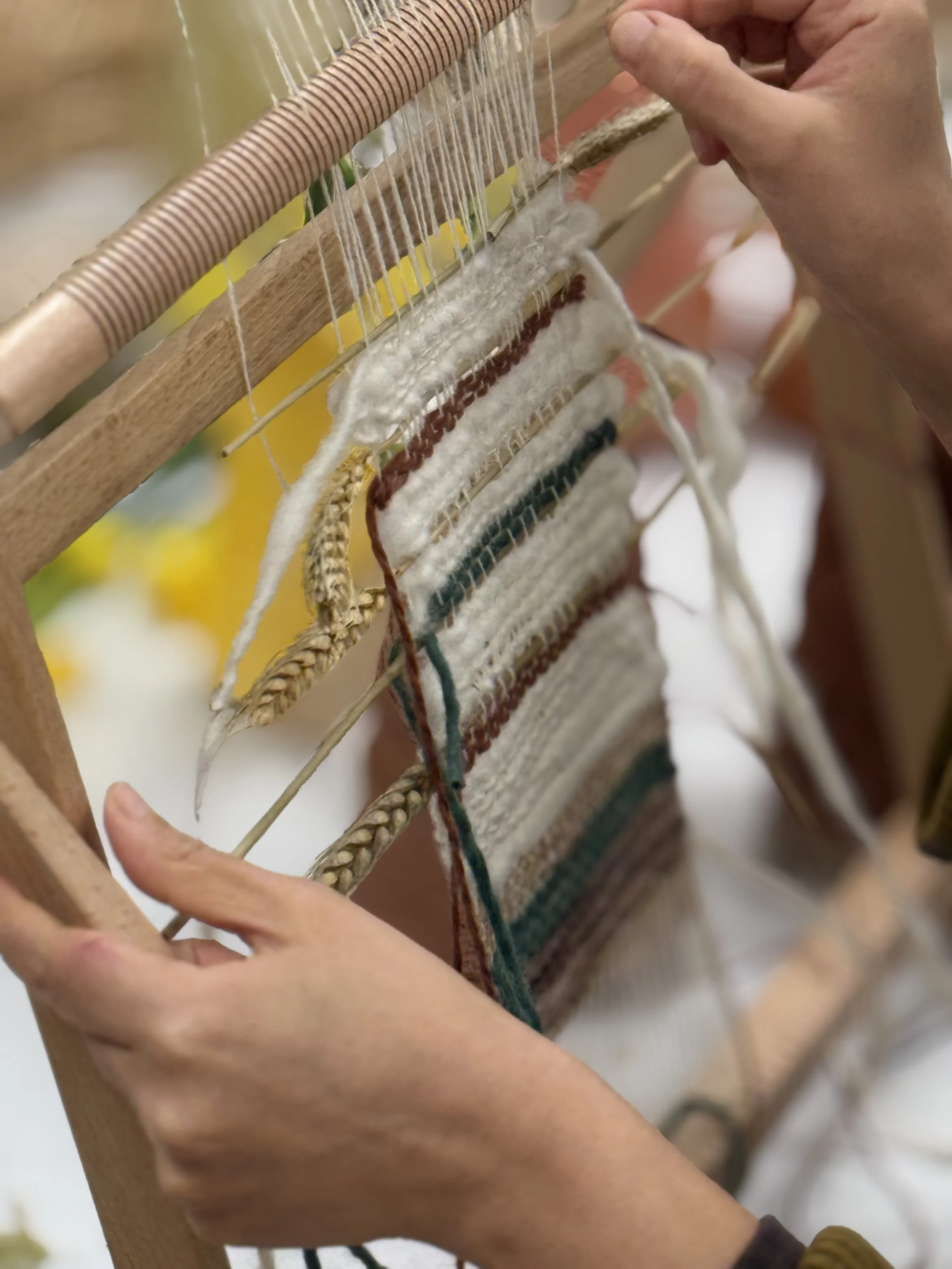 Participant weaving on a frame loom during a Peel Studio textile workshop exploring weaving, natural fibres, and slow craft techniques.