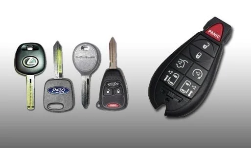 Varias llaves y controles remotos para autos sobre una superficie clara.