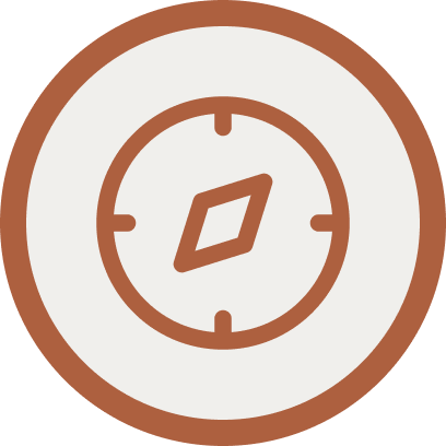 A compass with a brown outer ring and a white background, showing a diamond-shaped needle pointing northeast.