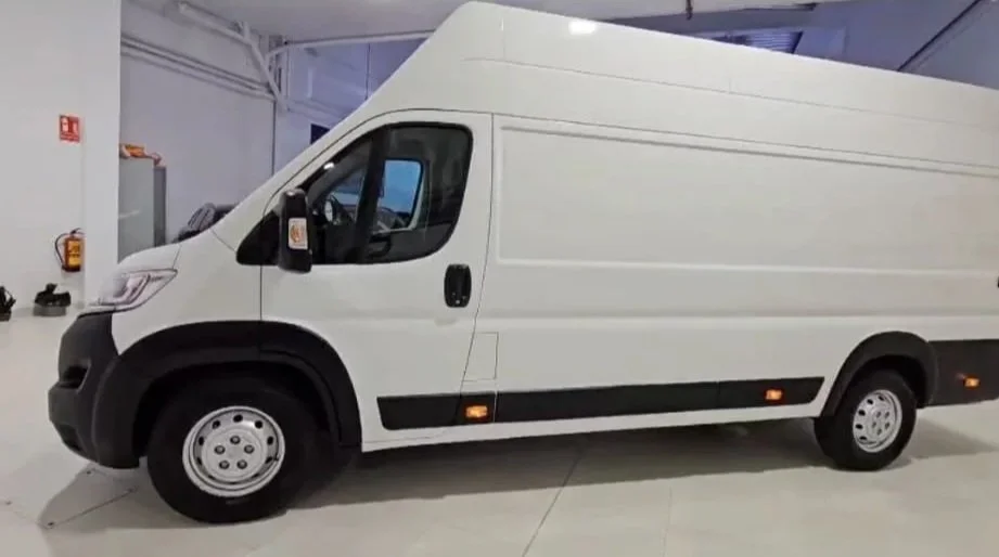 Vehículo de carga, una camioneta blanca, en un espacio cerrado como un garaje o almacén.