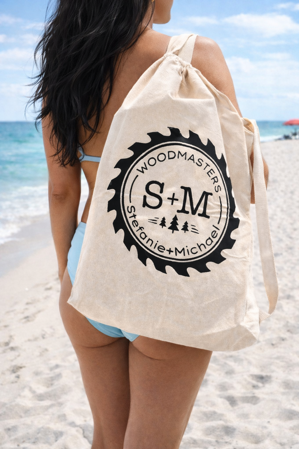 A girl in a blue bathing suit carrying a roll out table bag