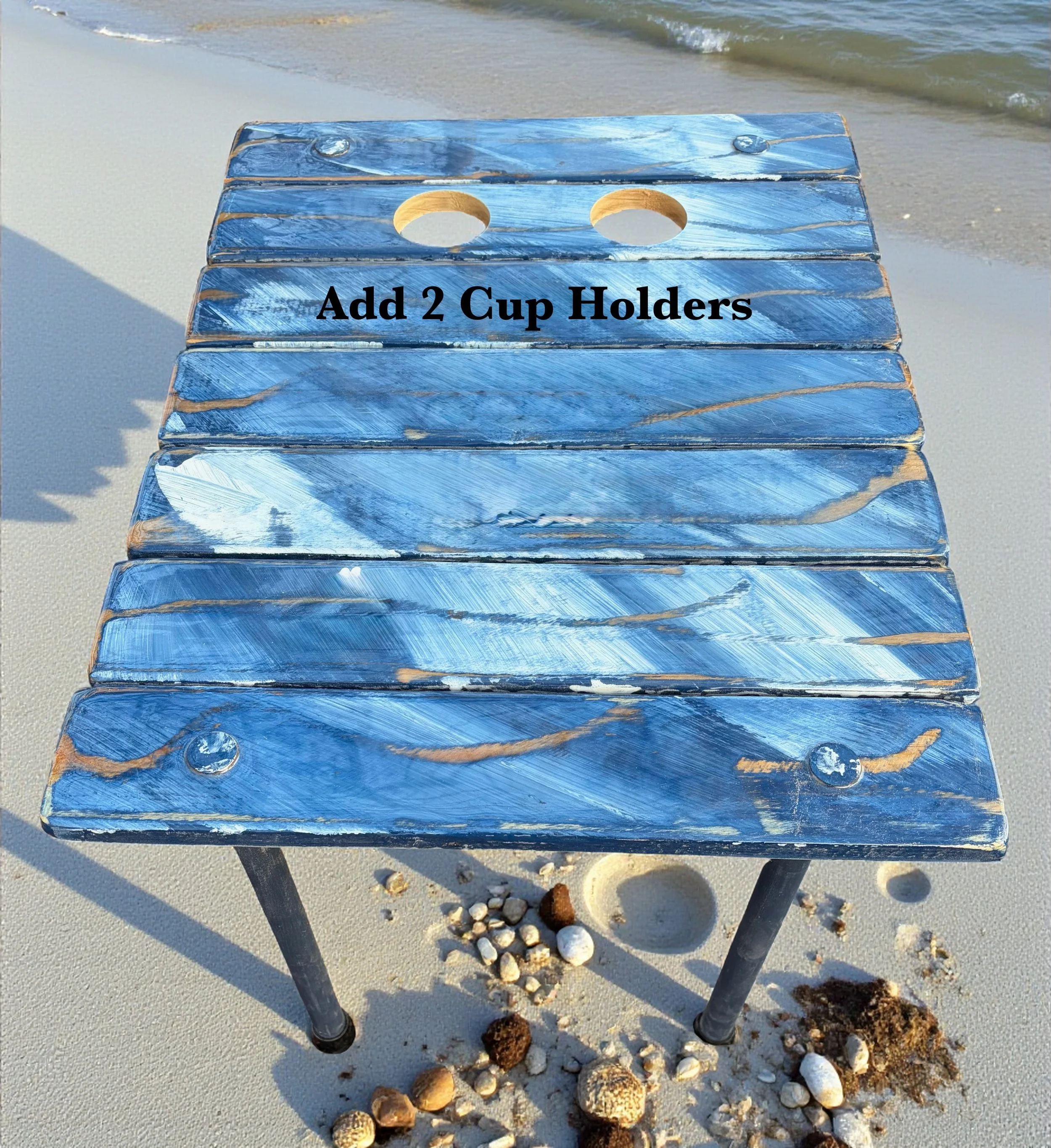 a denim blue table on the beach with cup holders, This table is portable