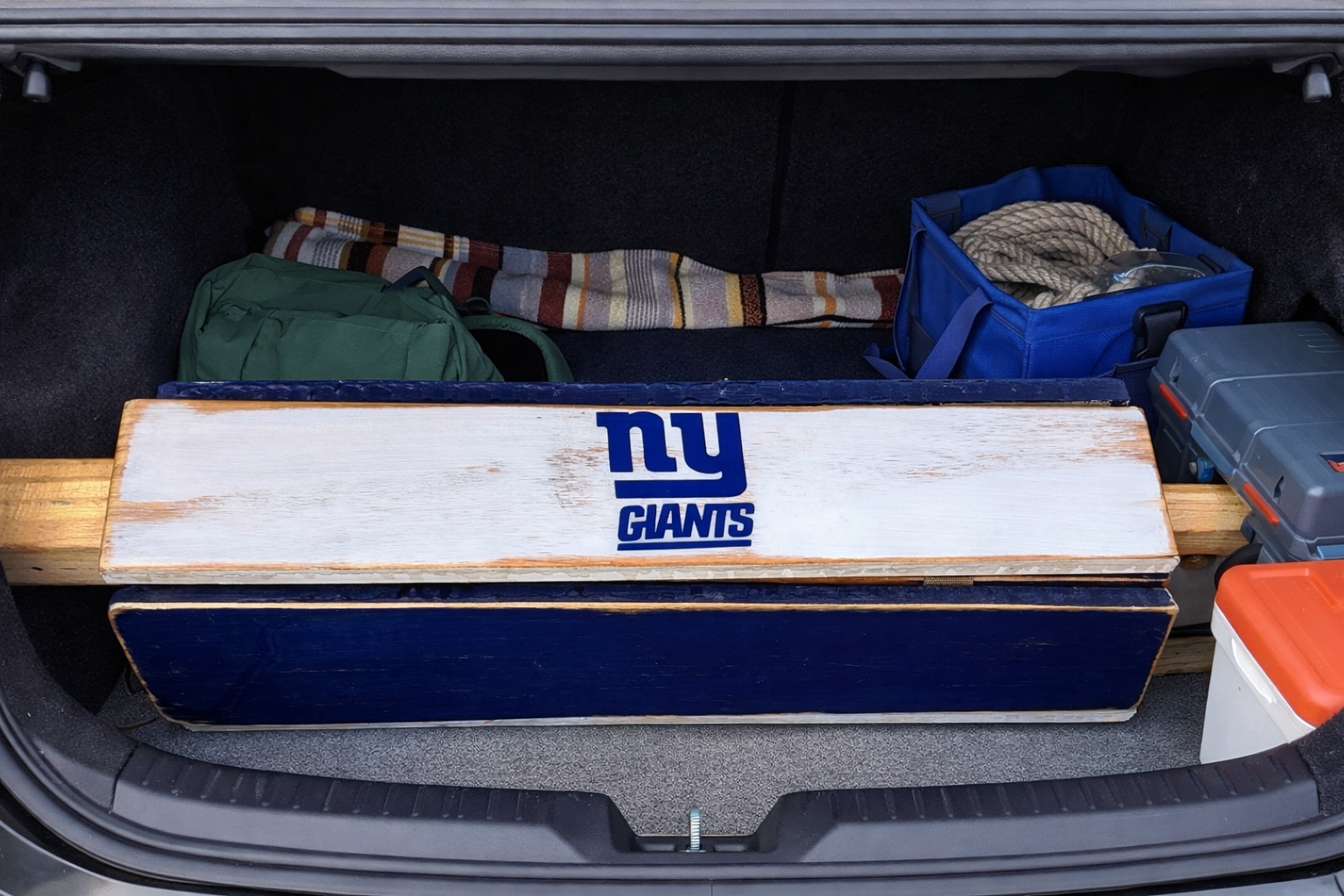 Handcrafted cedar roll-up table featuring NY Giants artwork, seen rolled up for easy storage