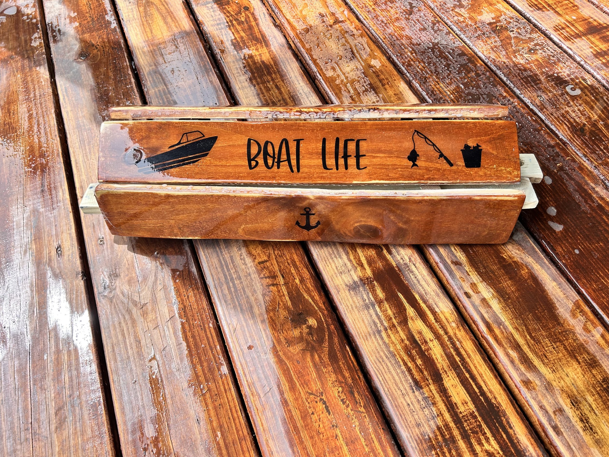 a cedar brown roll out table in a bag with a motor boat and fishing pole and the words "boat life" on a brown deck rolled up