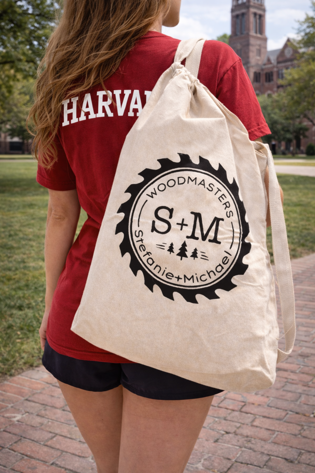 Woman wearing a Harvard shirt carrying S+M Woodmasters canvas roll-out table bag on Harvard campus