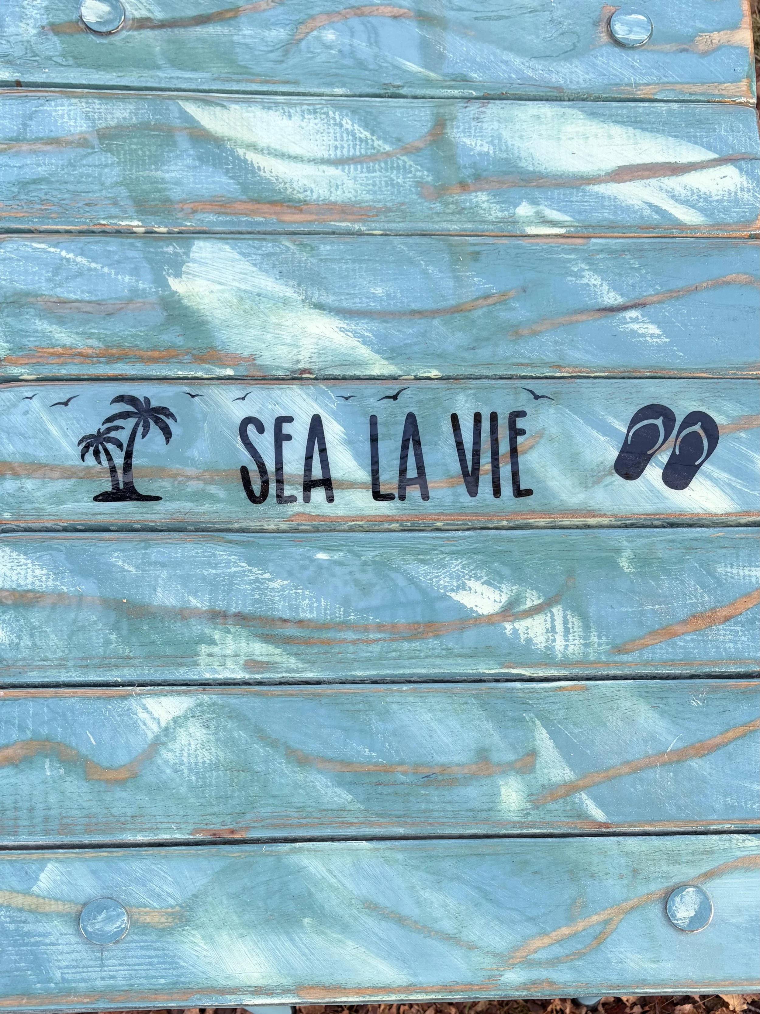 a close up of turquoise sea la vie roll out table in a bag on the beach