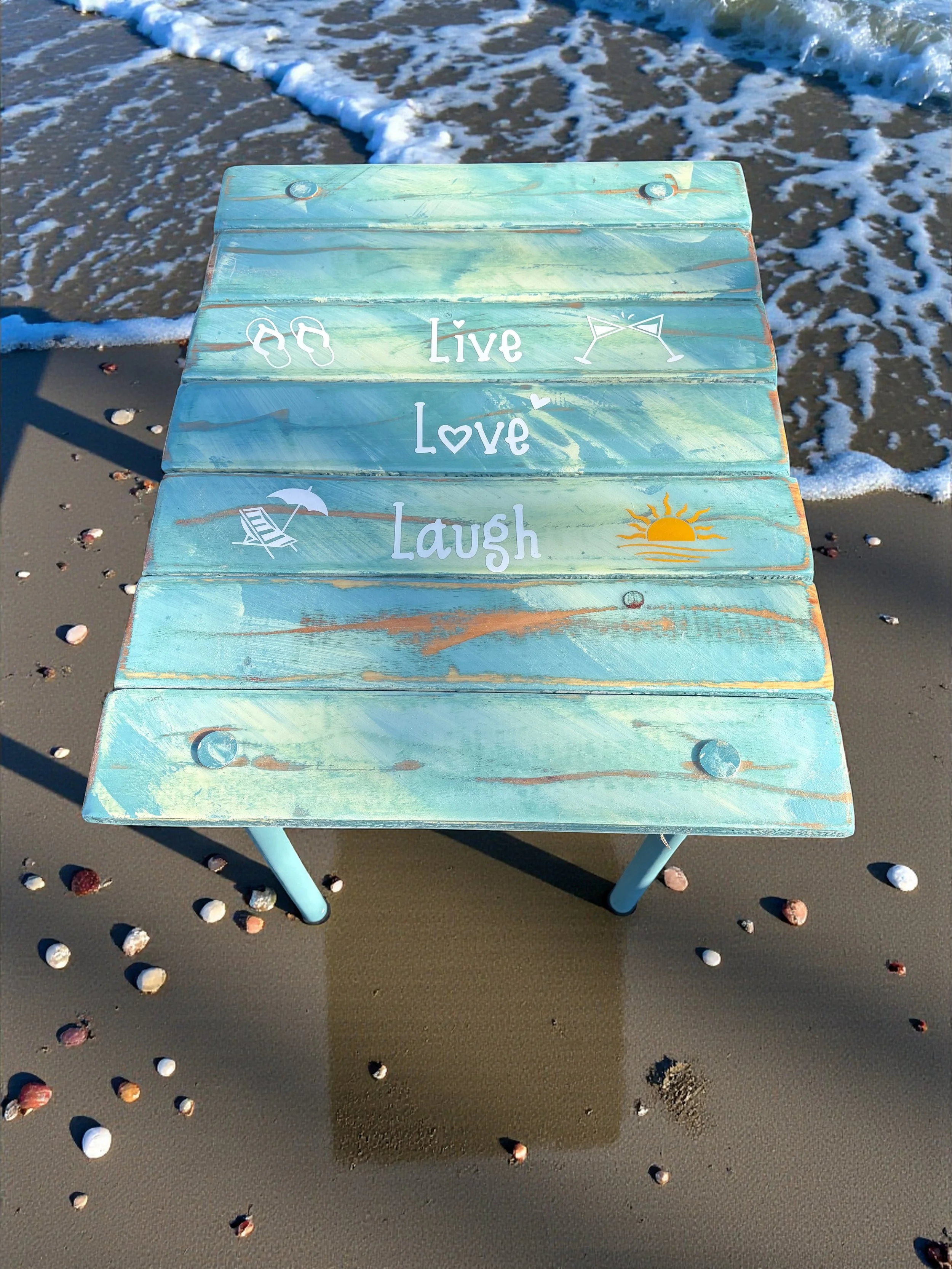 a turquoise beach table that says live love laugh on the beach