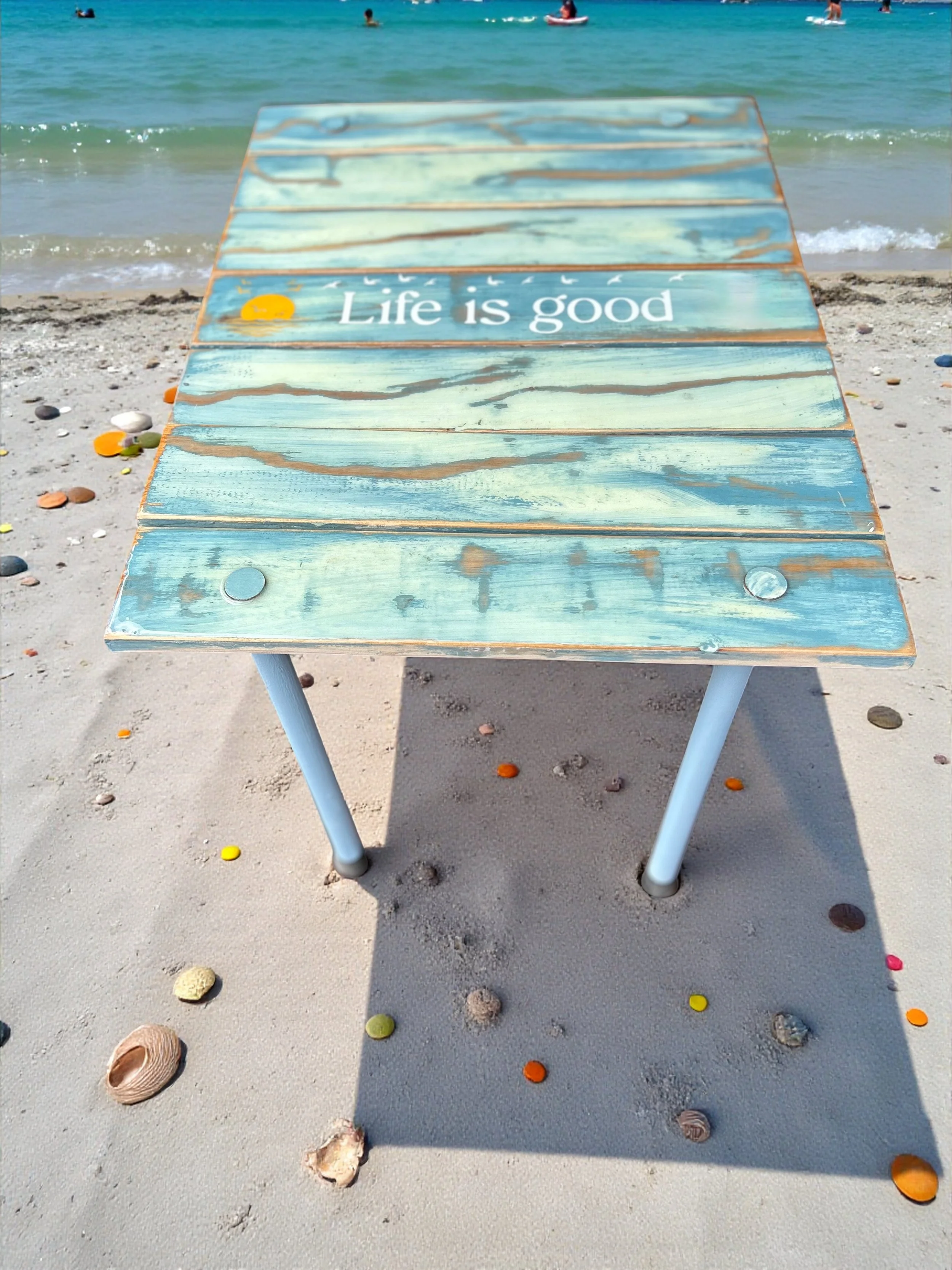 life is good turquoise  roll out table in a bag on a sandy beach