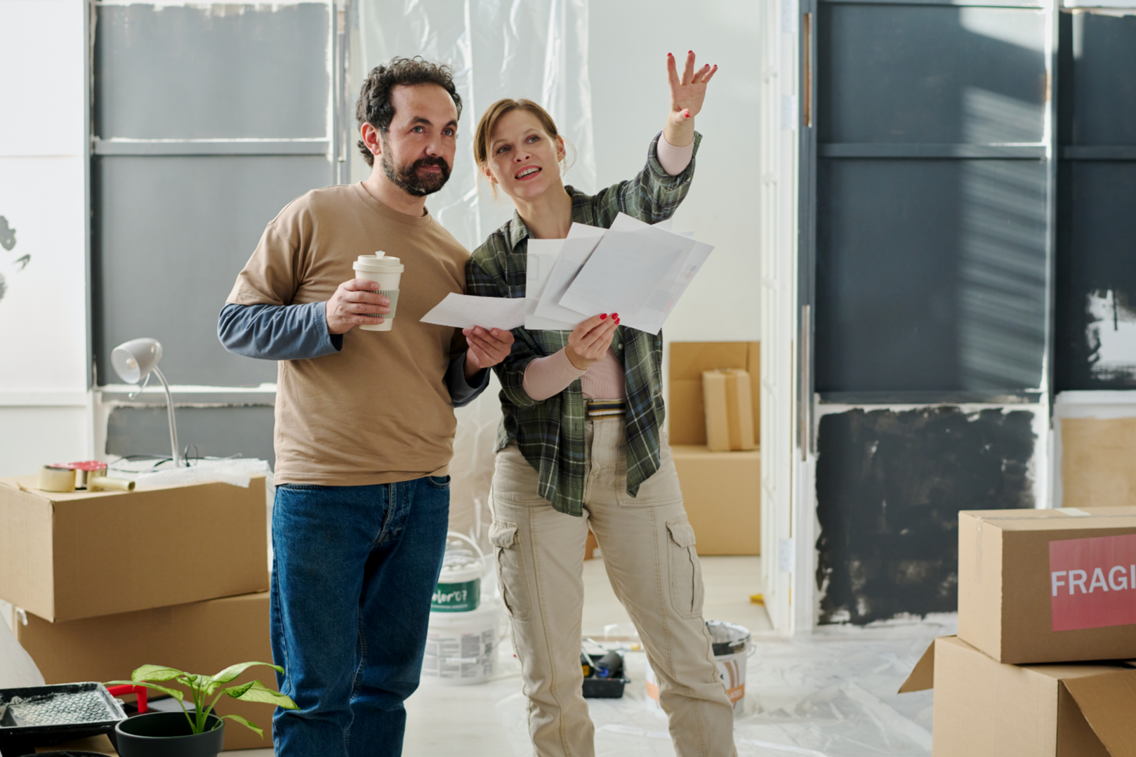 Mann in Jeans und beigem T-Shiert, Frau in beiger Cargo und kariertem Hemd bei der Renovierung, Foto, canva