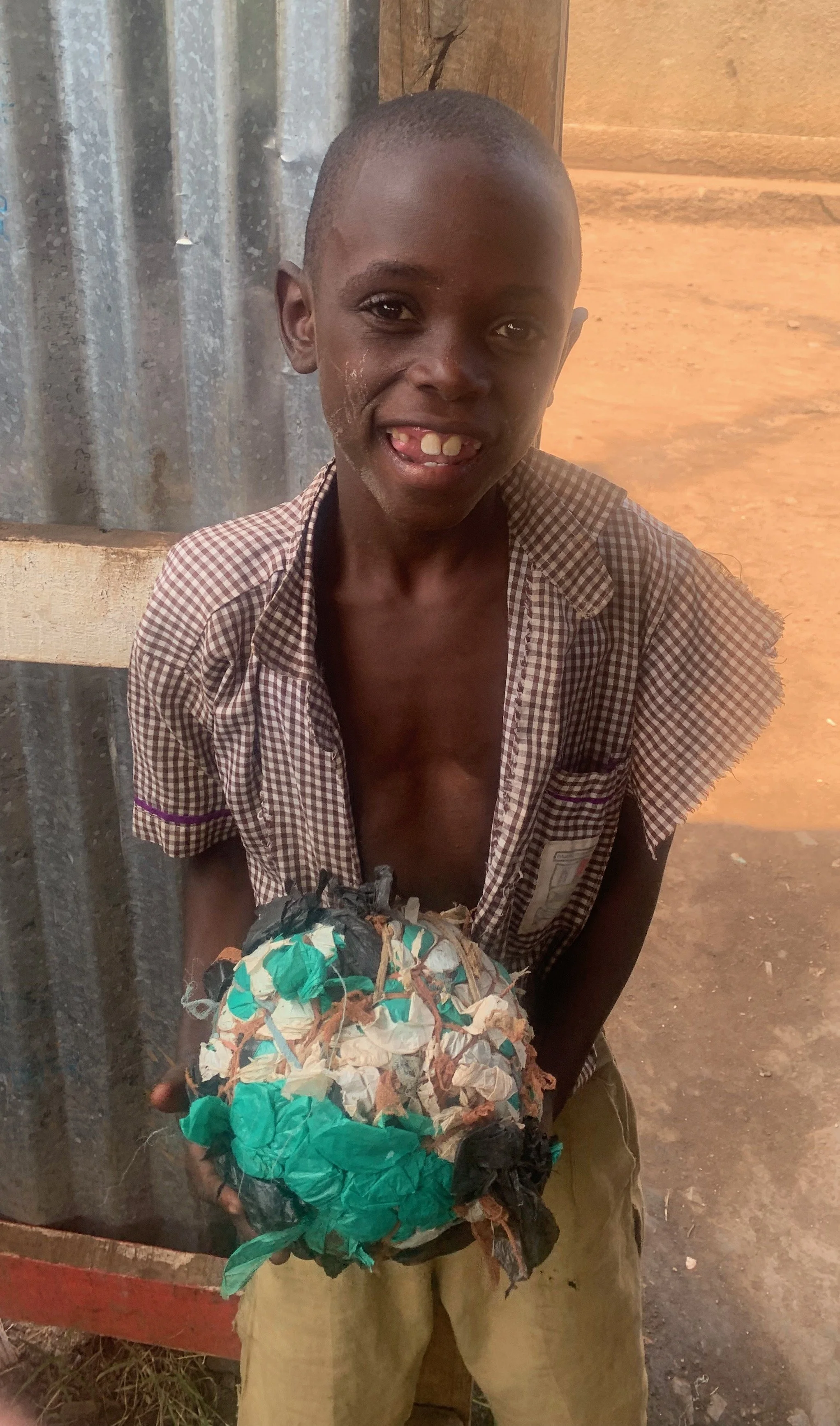 A deaf child with the school soccer ball—compressed plastic bags.