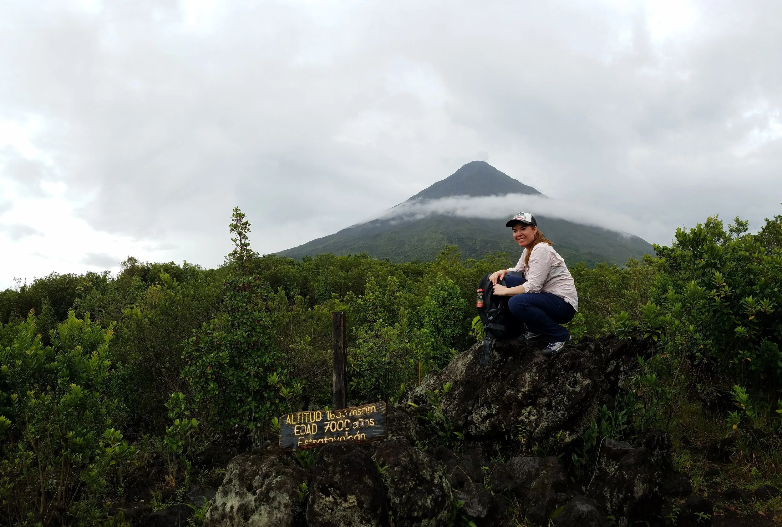 Woman hiking Arenal Volcano La Fortuna Costa Rica summit marker